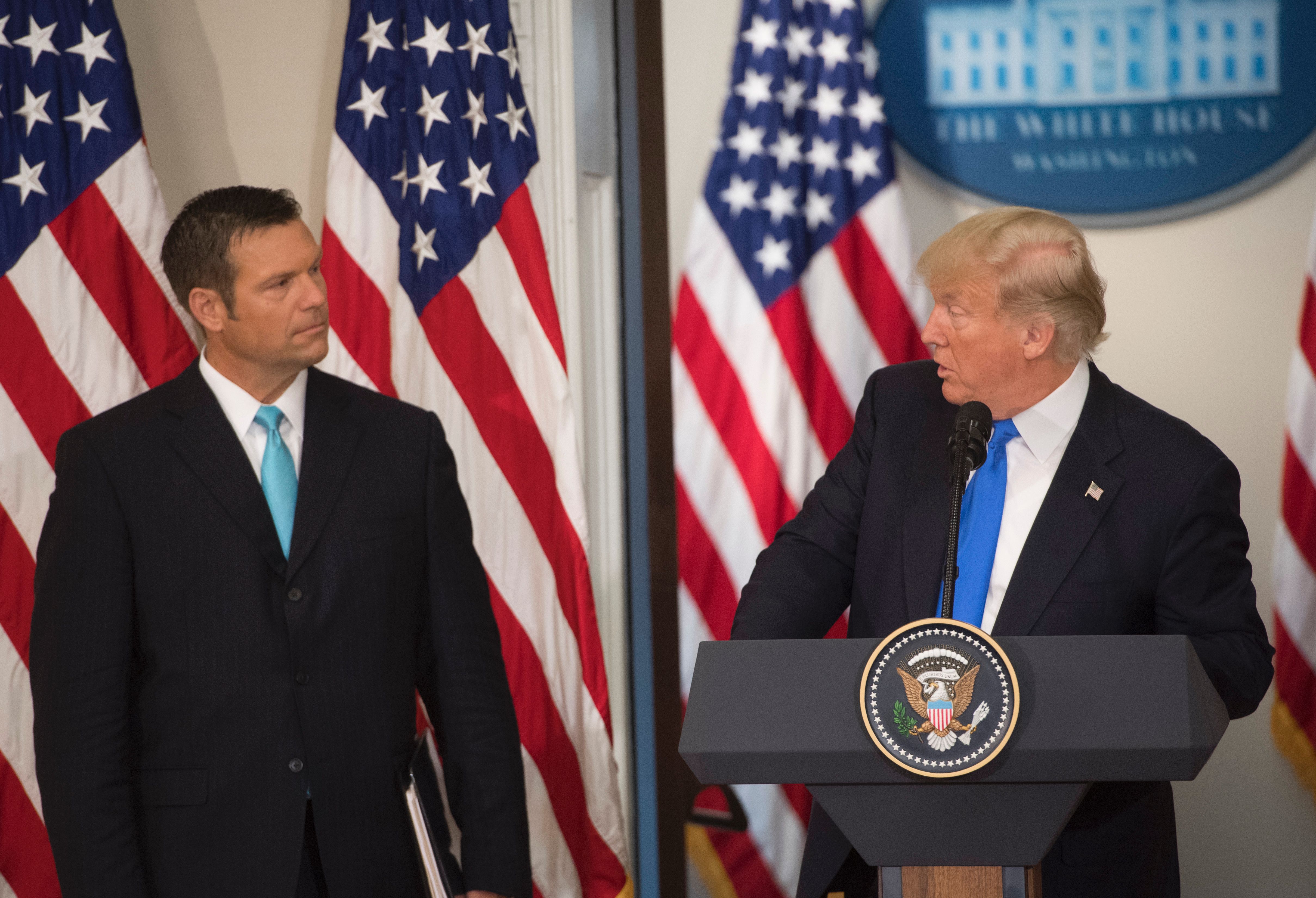 US President Donald Trump speaks alongside Kansas Secretary of State Kris Kobach (L) during the first meeting of the Presidential Advisory Commission on Election Integrity in the Eisenhower Executive Office Building next to the White House in Washington, DC, July 19, 2017. CREDIT: AFP PHOTO / SAUL LOEB