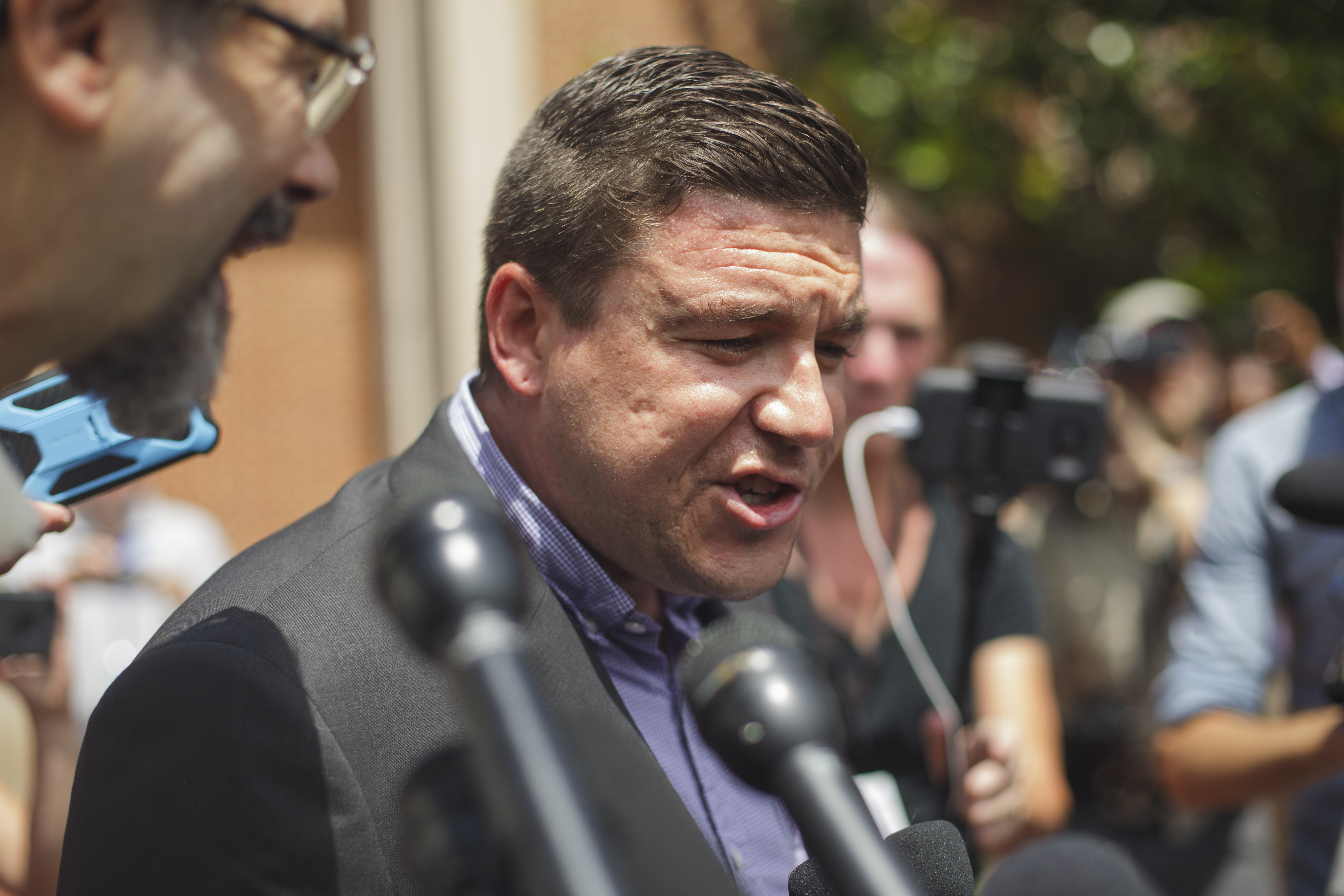Unite the Right organizer Jason Kessler waits for protesters to quiet before begnning a news conference in front of Charlottesville, Virginia, City Hall in this Aug. 13, 2017, file photo. A judge dismissed perjury charges against Kessler on Tuesday. CREDIT: Shay Horse/NurPhoto via Getty Images