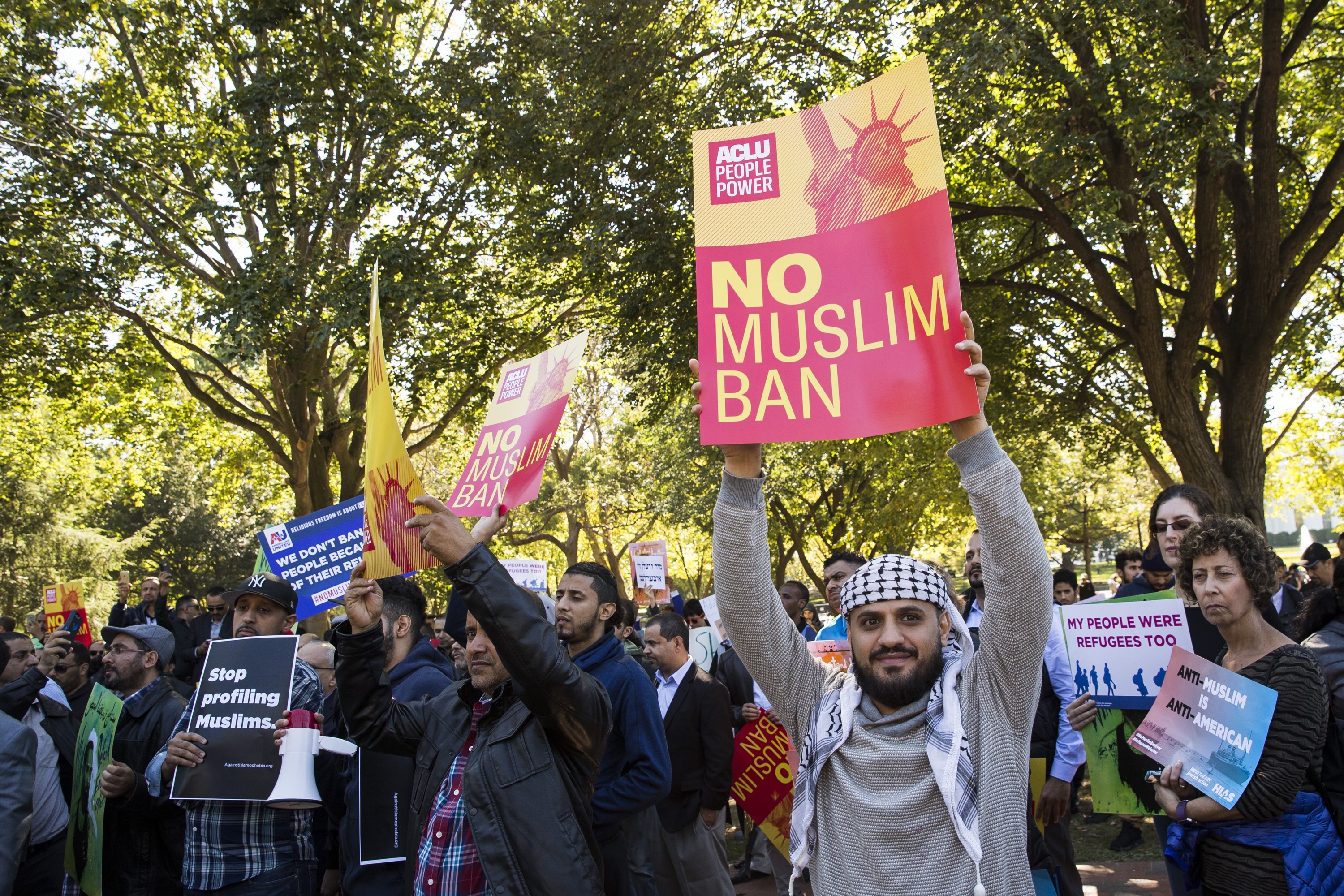 People hold up banners reading "No Muslim Ban", "Stop Profiling Muslims" during a protest against U.S President Donald Trump's Travel Ban, which was blocked a third time by Federal Courts, in Washington, United States on October 18, 2017. (Credit: by Samuel Corum/Anadolu Agency/Getty Images)