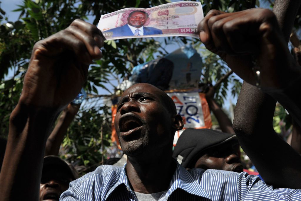 A supporter of the Kenyan opposition (NASA) coalition leader holds a fake bank note with his portrait as he prepares to have himself sworn in as the 'people's president' on January 30, 2018 in Nairobi. CREDIT: TONY KARUMBA/AFP/Getty Images