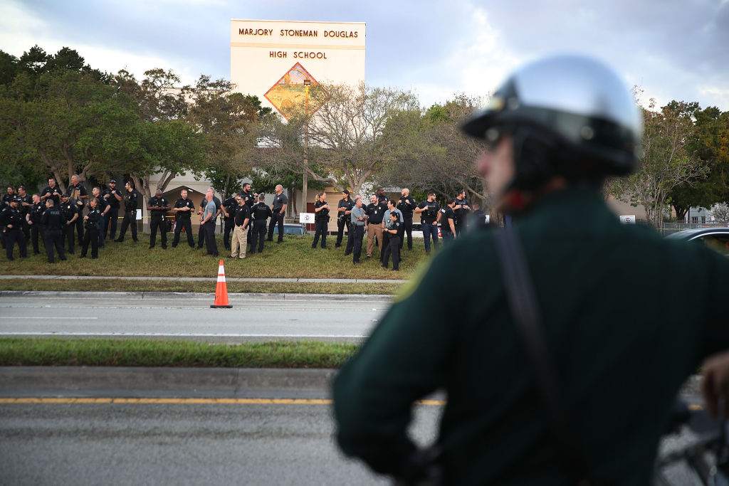 Police officers stand in front of Marjory Stoneman Douglas High School as students return after February's mass shooting. CREDIT: Joe Raedle/Getty Images