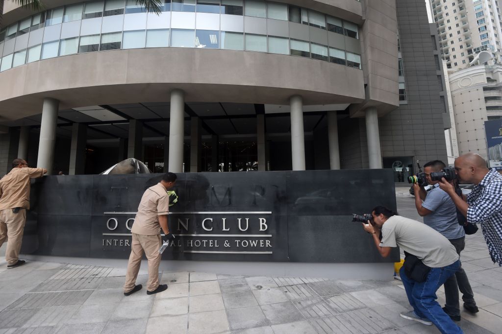 Hotel workers clean the sign of the former Trump International Hotel & Tower Panama after the Trump brand name was removed. CREDIT: RODRIGO ARANGUA/AFP/Getty Images
