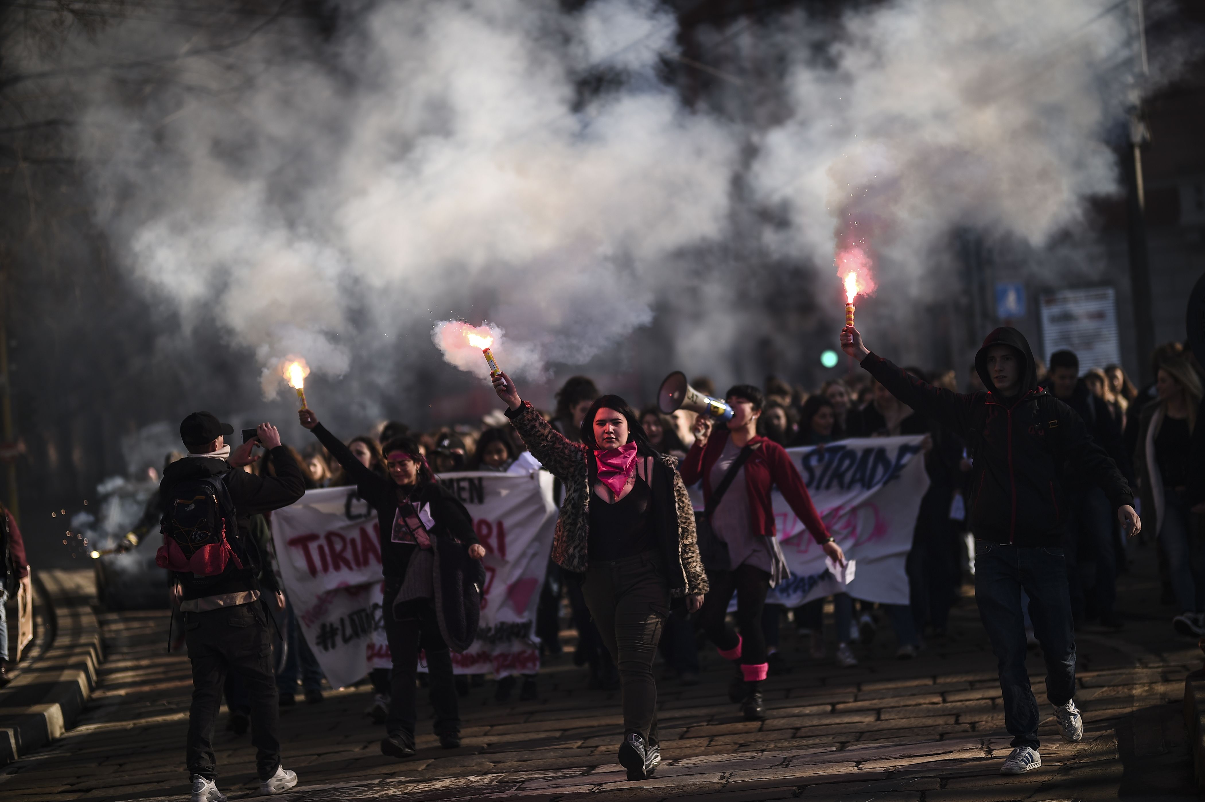 Young women light flares during the Women March against Violence as part of International Women's day, on March 8, 2018 in Milan. (CRDIT: MARCO BERTORELLO/AFP/Getty Images)