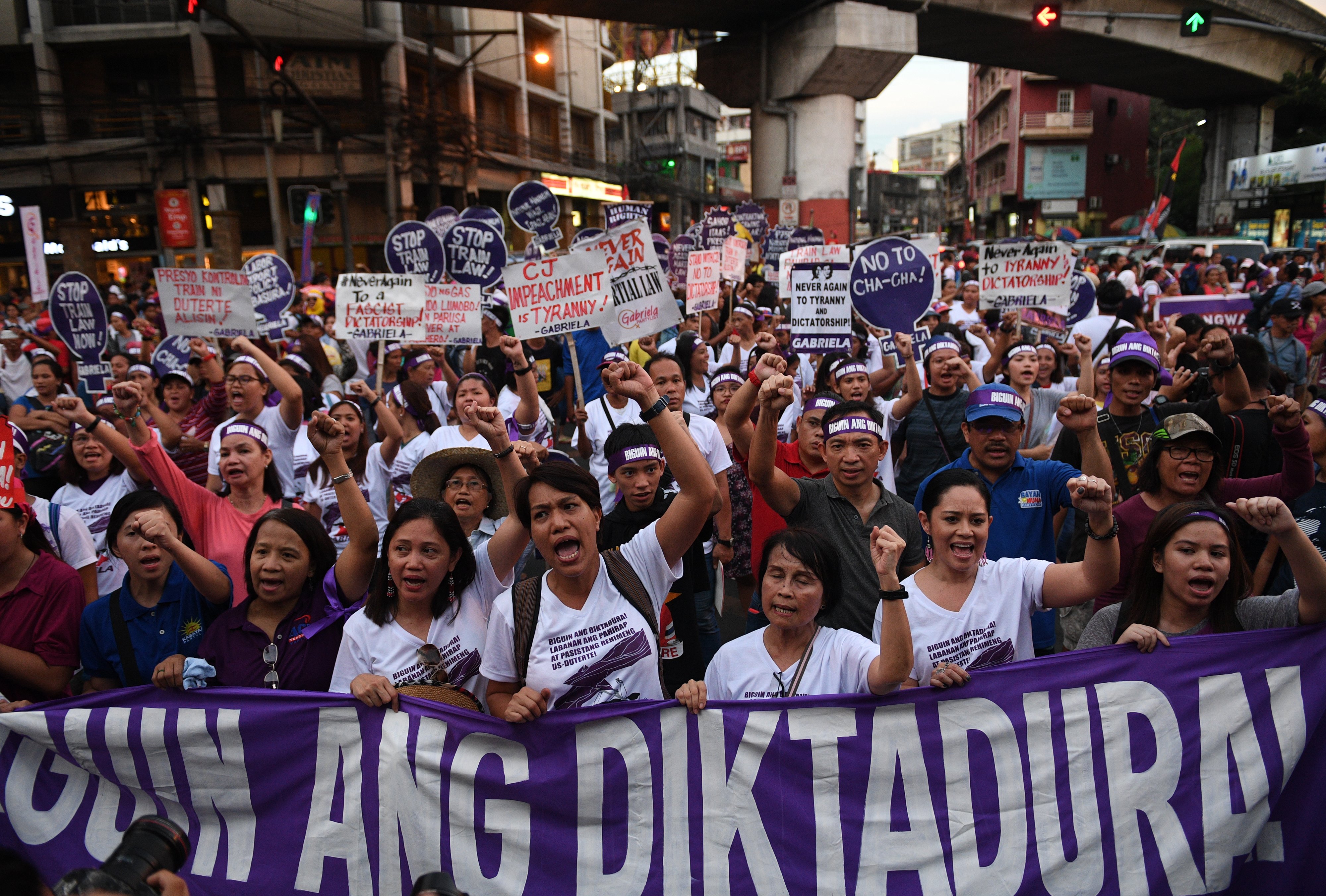 Protesters carry a streamer that reads 'fight dictatorship' during a rally near Malacanang palace as part of the celebration of International Women's Day in Manila on March 8, 2018.
The protesters assailed the government of President Rodrigo Duterte on issues ranging from continued violence against women, drug war, tax reform program, and changing of the constitution among others. (CREDIT: TED ALJIBE/AFP/Getty Images)