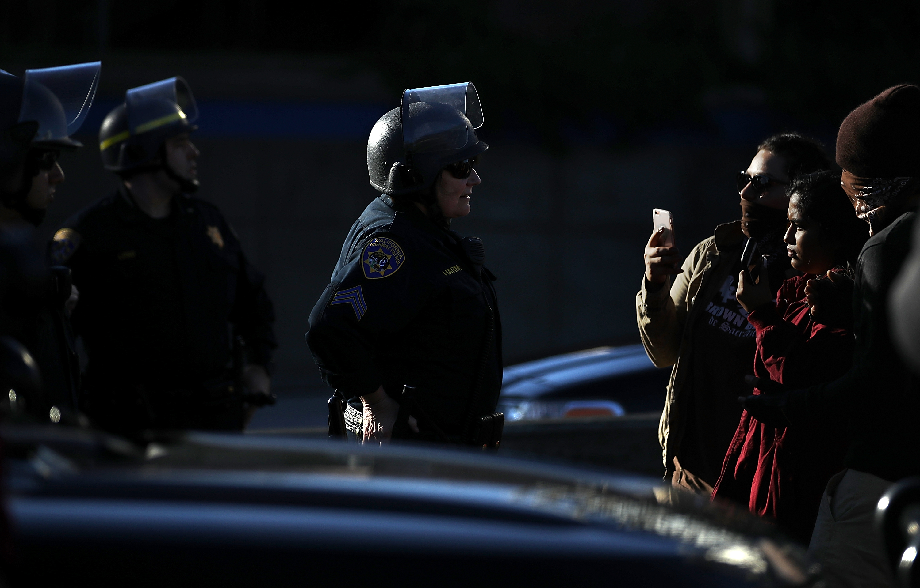 Protesters film an interaction with California Highway Patrol officers during the blockade of I-5. CREDIT: Justin Sullivan/Getty Images