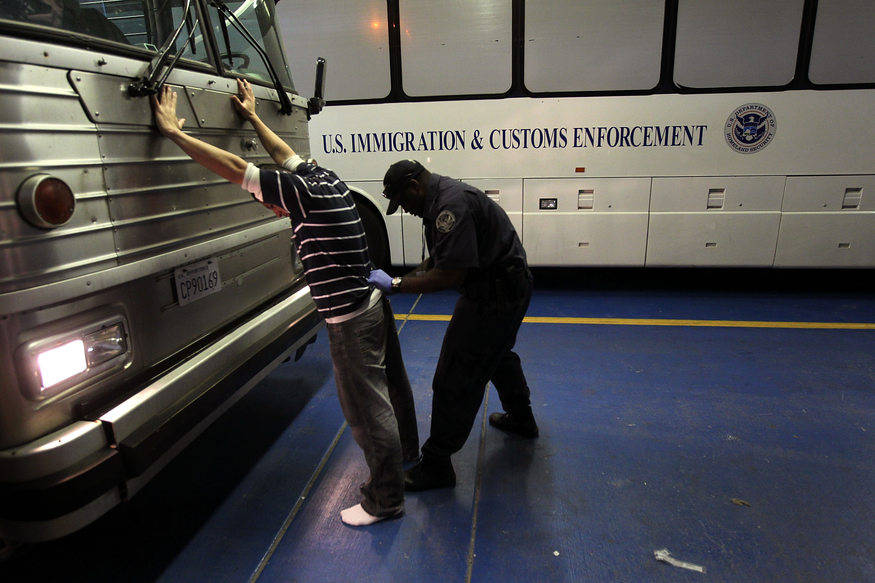 An undocumented Mexican immigrant is searched while being in-processed in Phoenix. CREDIT: John Moore/Getty Images