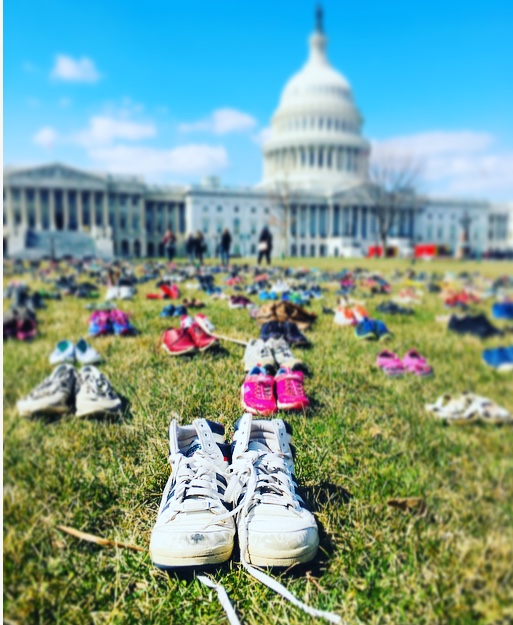 Daniel Mauser's white shoes (center-front) are among the 7,000 shoes on display in a monument to the 7,000 children killed by gun violence since the Sandy Hook Elementary School shooting. Mauser was killed at Colorado's Columbine High School in 1999. His father wore the shoes to bring to the memorial. (CREDIT: Esther Y. Lee)