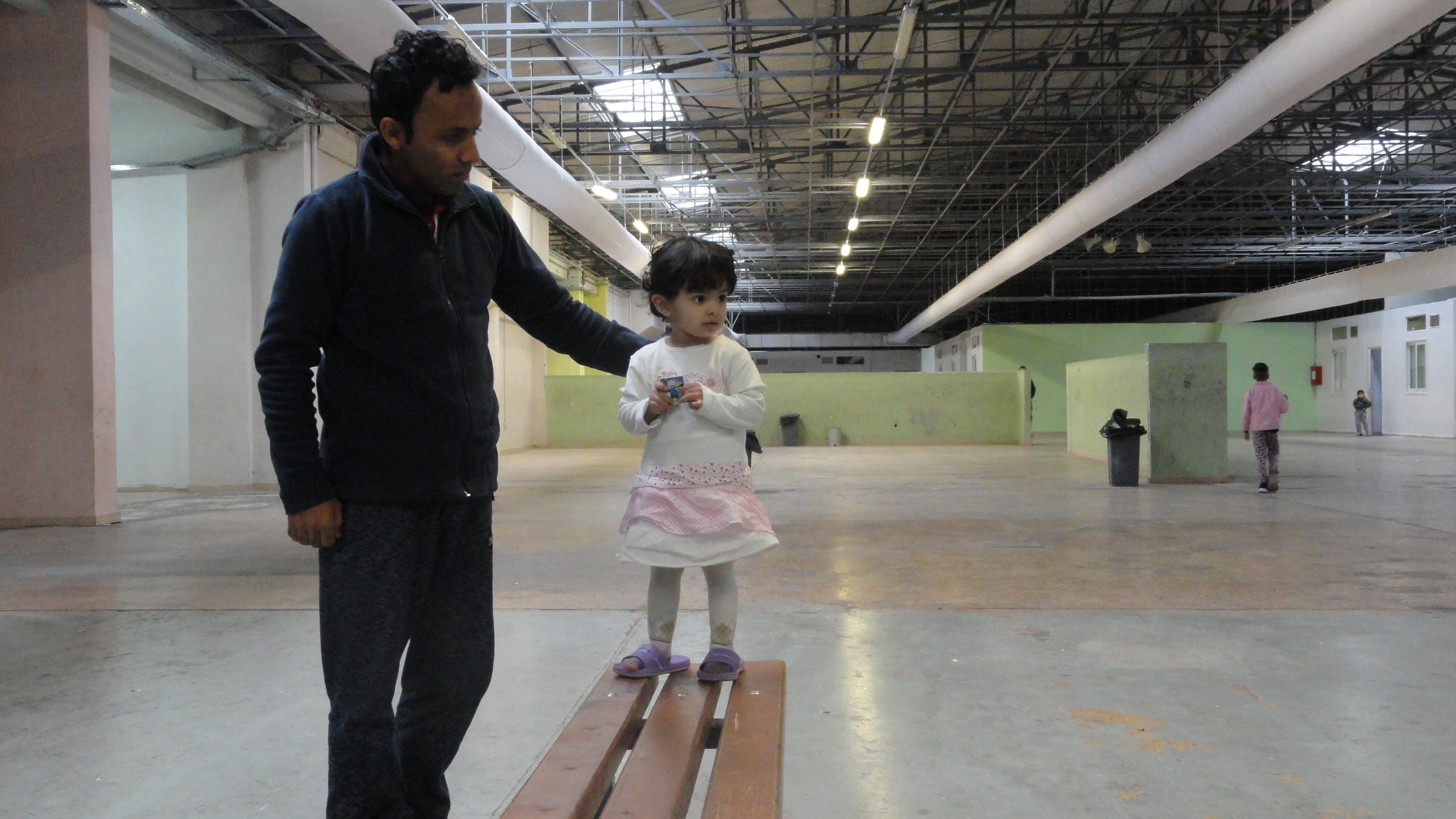 Mohmad and his daughter, Asieh, at the Thivu refugee housing facility -- a converted factory with 63 container apartments inside the factory and 65 outside. Each container houses a maximum of eight people. CREDIT: D. Parvaz/ThinkProgress.