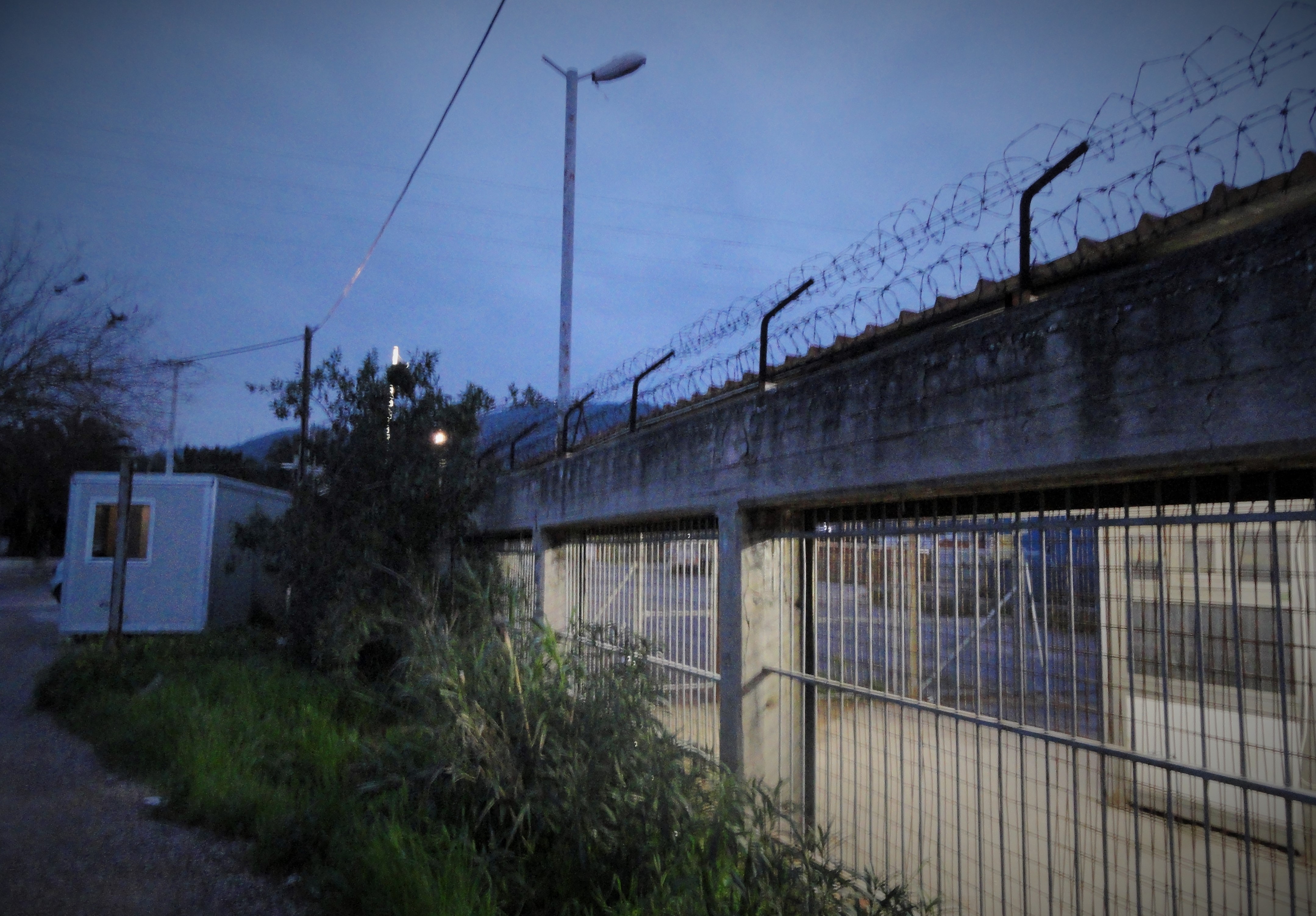 The Skaramagas refugee housing camp looks somewhat like a prison from the outside, but residents have total freedom of movement. Although it's unclear if there are any Greek authorities currently overseeing the facility, or providing services. CREDIT: D. Parvaz/ThinkProgress.