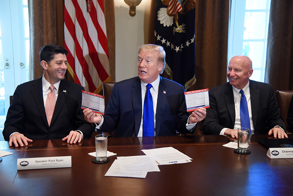 U.S. President Donald Trump speaks while holding up a postcard-sized tax form. Credit: Olivier Douliery/Bloomberg via Getty Images