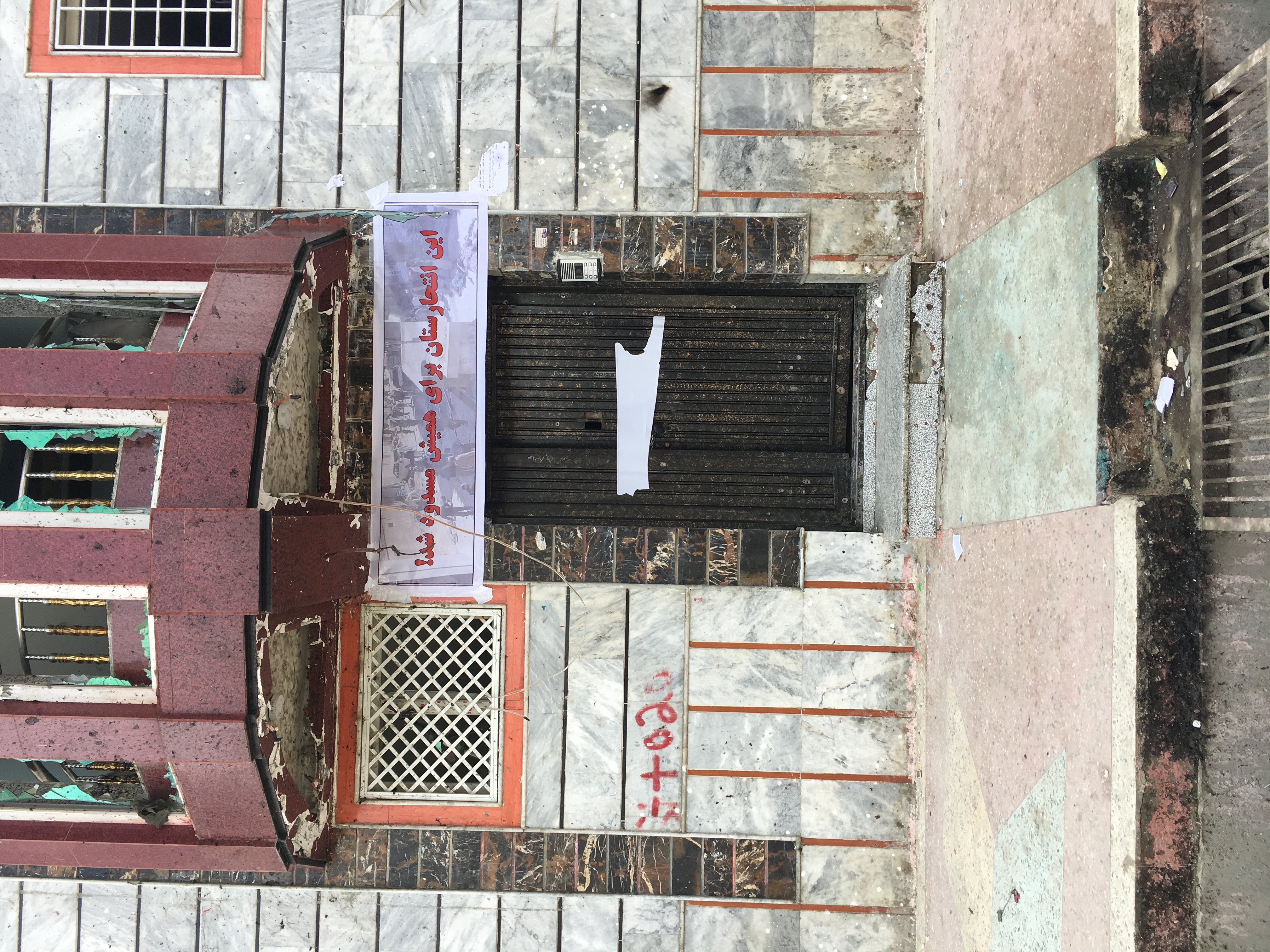 A sign outside the voter registration center where Sunday's attack took place now reads “This land of suicide bombings is forever closed.” (Credit: Ali Latifi for ThinkProgress)