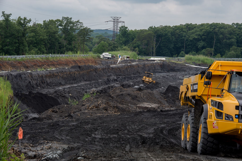 Heavy machinery excavate and carry coal ash from a drained coal ash pond at Dominion Power's Possum Point Power Station in Dumfries, Virginia. CREDIT: Kate Patterson for The Washington Post via Getty Images