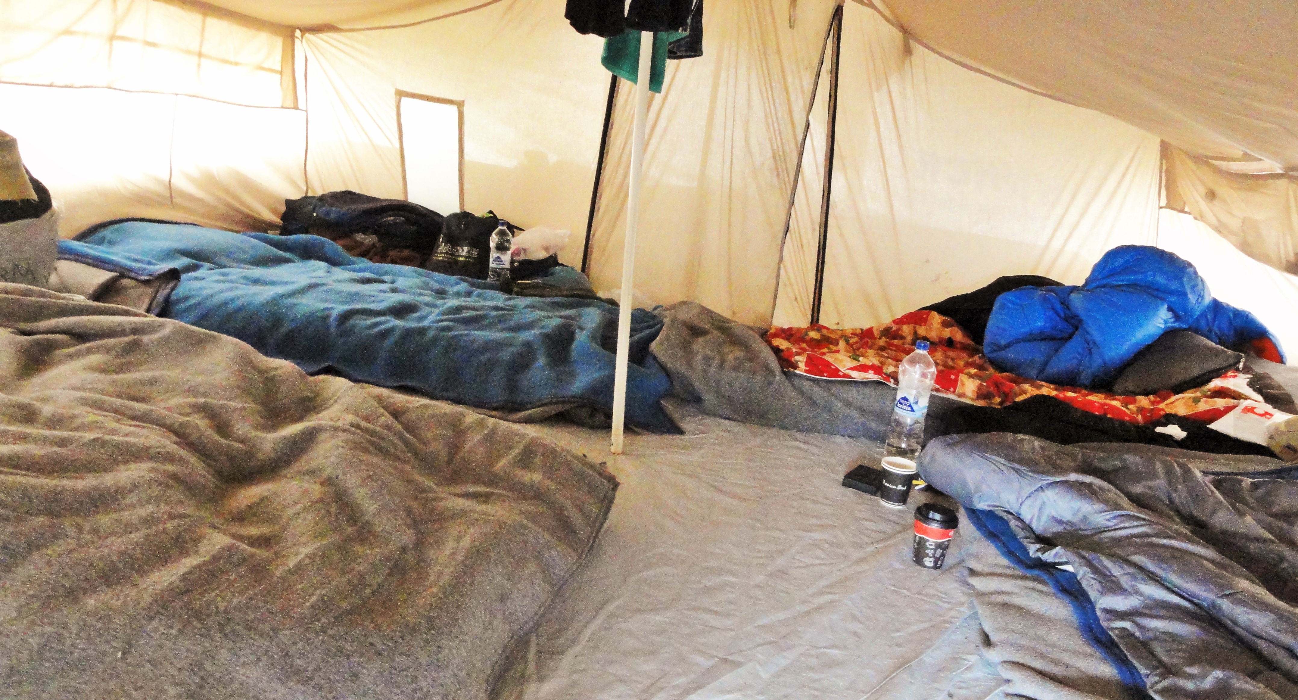 This tent, pitched on the slope of a muddy hill outside the Moria camp on the island of Lesbos, is home to eight men who could no longer tolerate the conditions inside the camp, opting to move out into the informal camp dubbed the Olive Grove. CREDIT: D. Parvaz/ThinkProgress.