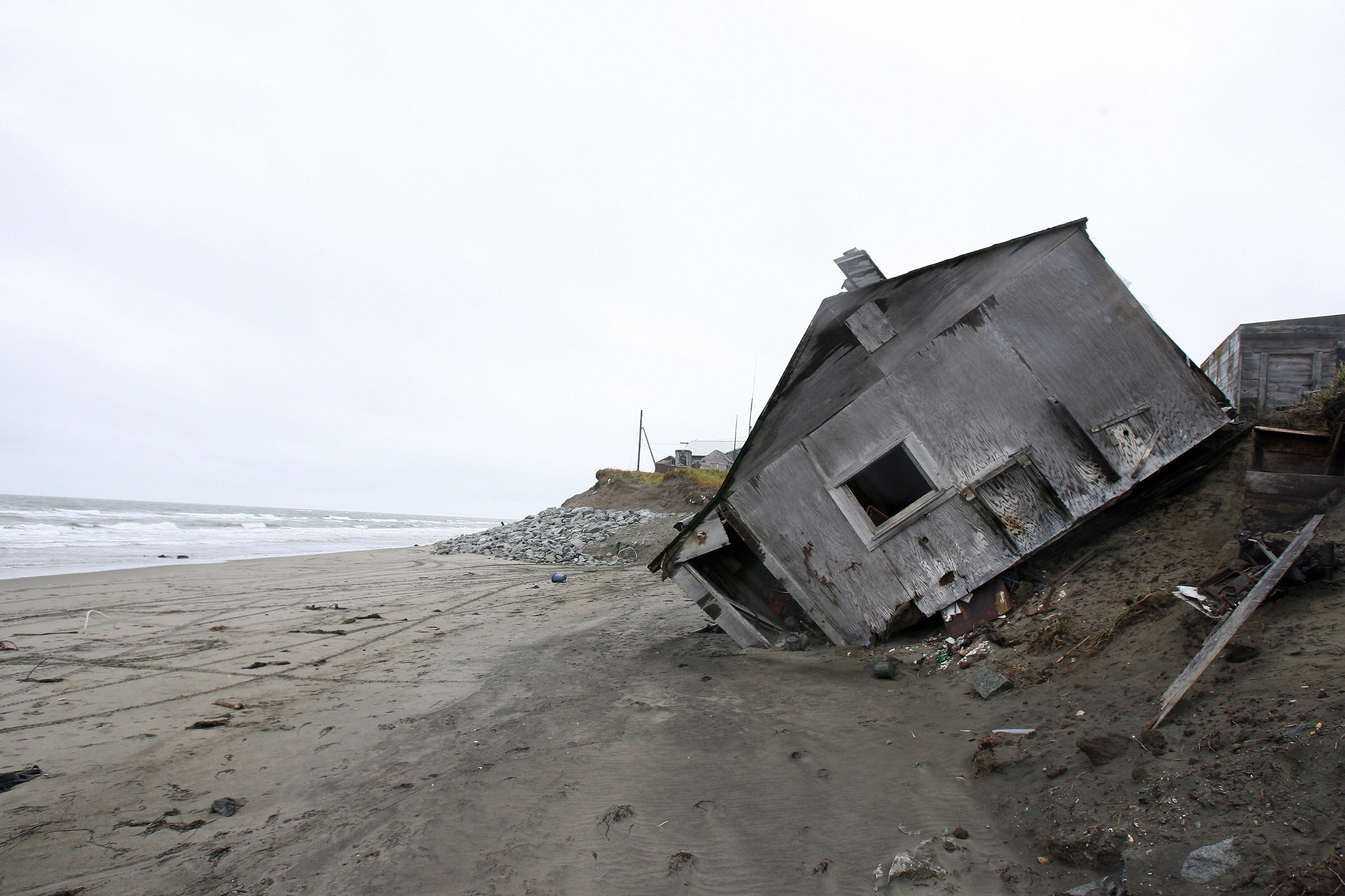 In September 2006 a home was destroyed by beach erosion; it lies on its side in the Alaskan village of Shishmaref. (Credit: GABRIEL BOUYS/AFP/Getty Images)