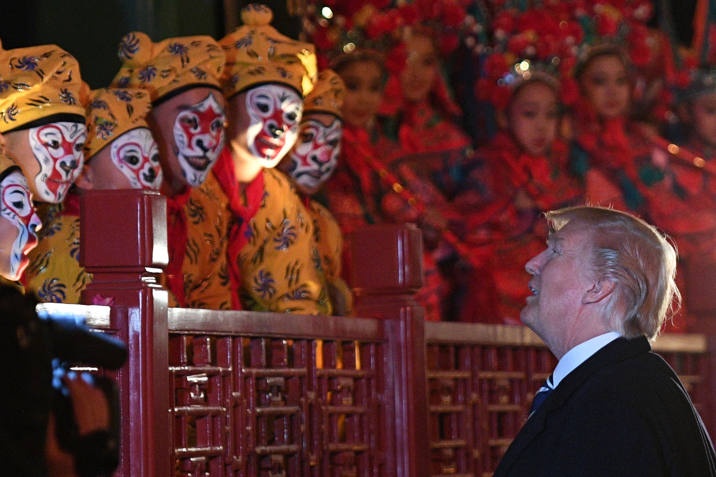 TOPSHOT - US President Donald Trump talks to opera performers during a visit late last year to Beijing. CREDIT: JIM WATSON