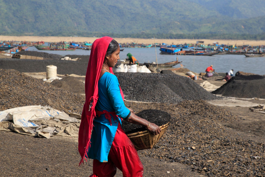 Workers seen collecting coal from Jadukata River at Tahirpur on December 18, 2017 in Dhaka, Bangladesh. CREDIT: Rehman Asad / Barcroft Media via Getty Images