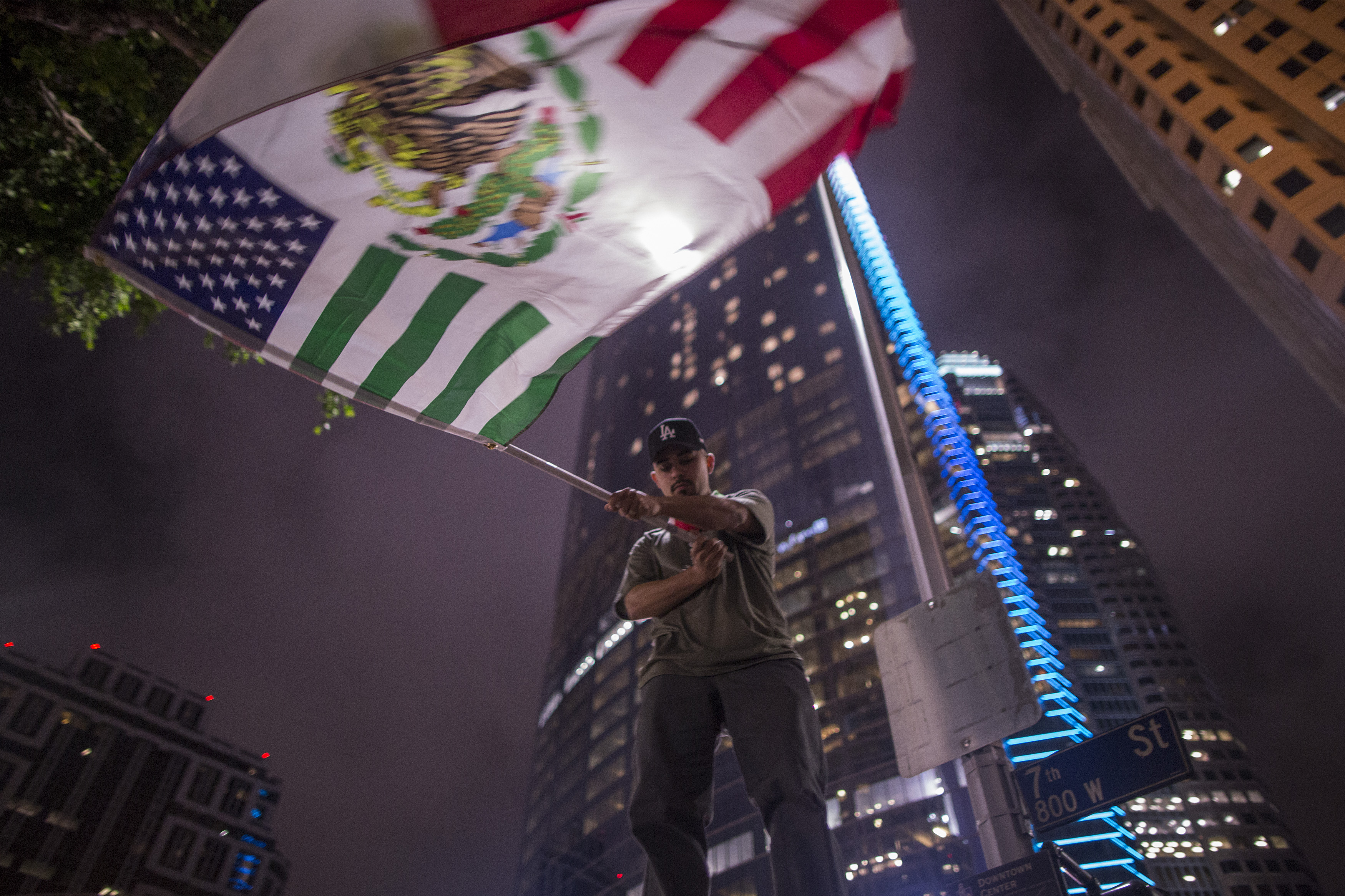 A protester waves a flag composed of elements of the U.S. and Mexican flags in downtown Los Angeles in March 2018, when President Trump went to California to view border wall prototypes. CREDIT: David McNew/Getty Images.