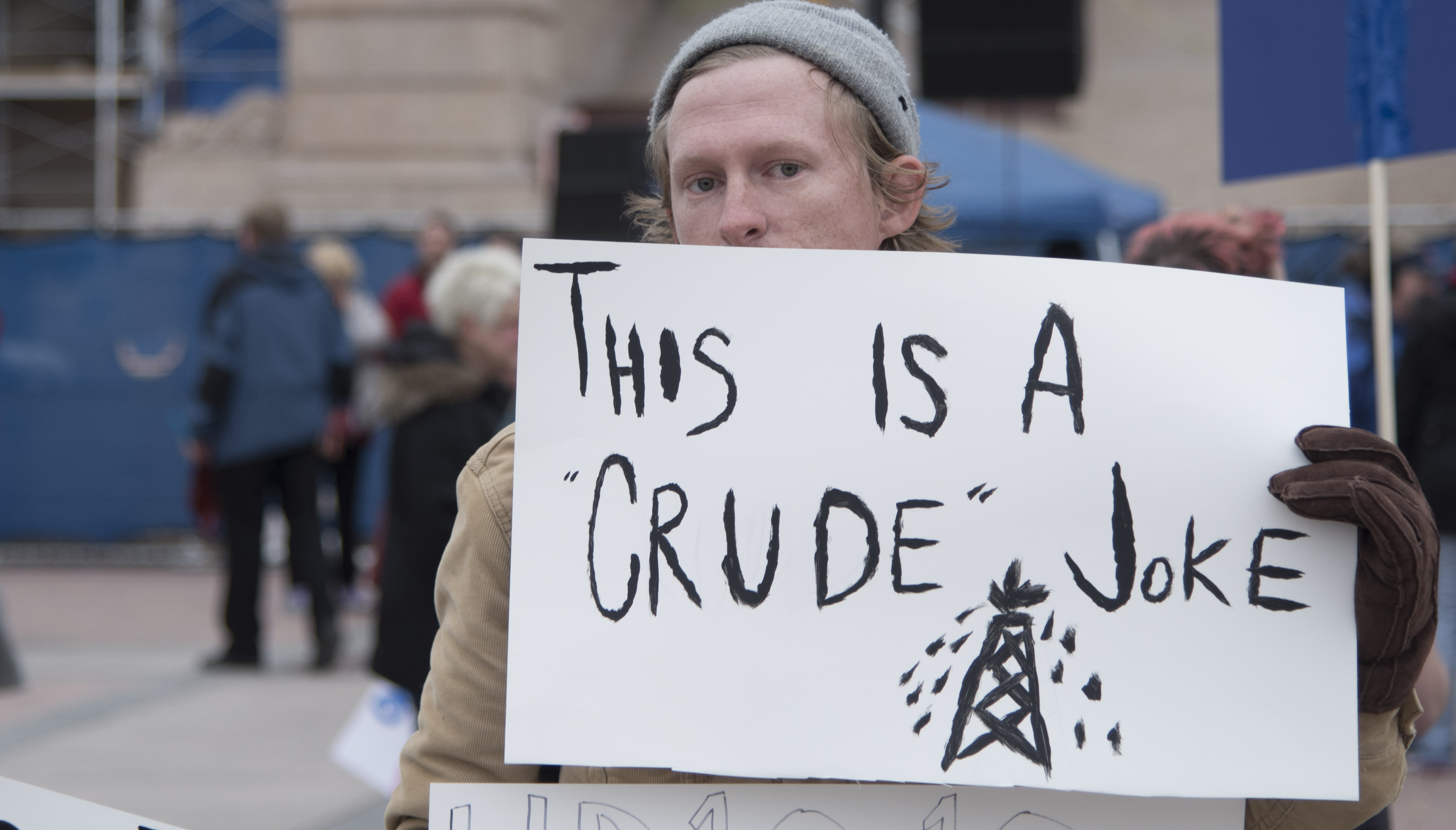 Conner McElveen, an Oklahoma City teacher, holds a protest sign about the lacking of taxation on the oil industry, at the state capitol on April 2, 2018 in Oklahoma City, Oklahoma. (CREDIT: J Pat Carter/Getty Images)