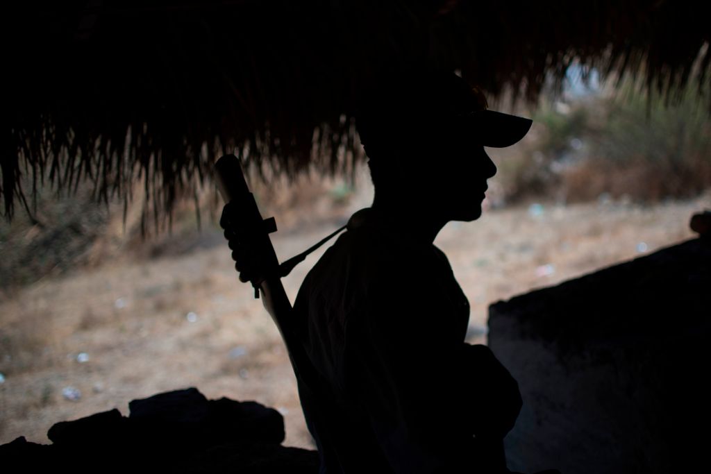 A Guerrero Community Police member stands guard at a checkpoint in Apaxtla de Castrejon, Guerrero state, Mexico, on March 26, 2018. - In the mountainous area of Guerrero state, one of the poorest and the most violent of Mexico. (Photo credit should read PEDRO PARDO/AFP/Getty Images)