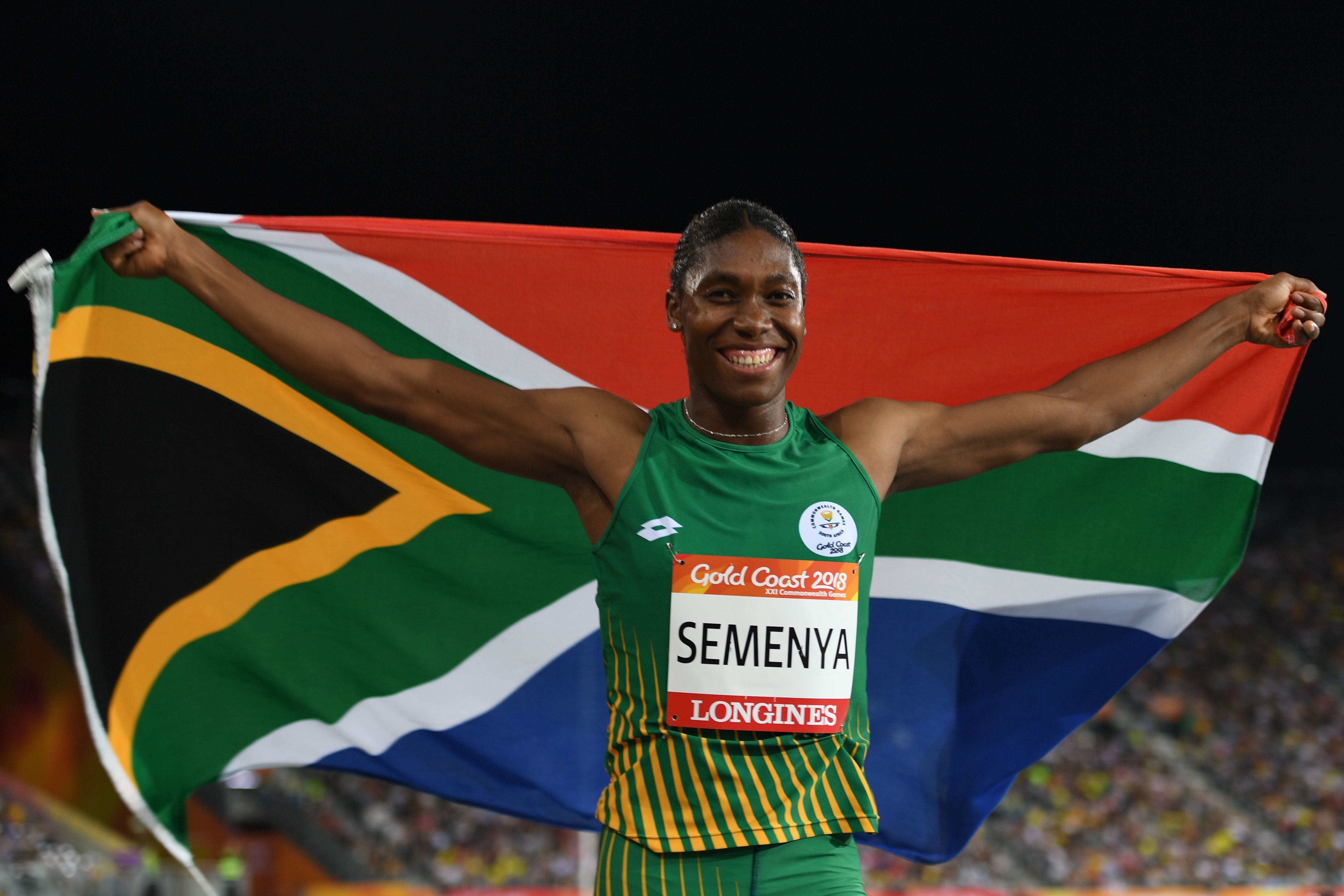 South Africa's Caster Semenya celebrates with flag after winning the athletics women's 800m final during the 2018 Gold Coast Commonwealth Games at the Carrara Stadium on the Gold Coast on April 13, 2018. / AFP PHOTO / SAEED KHAN (Photo credit should read SAEED KHAN/AFP/Getty Images)