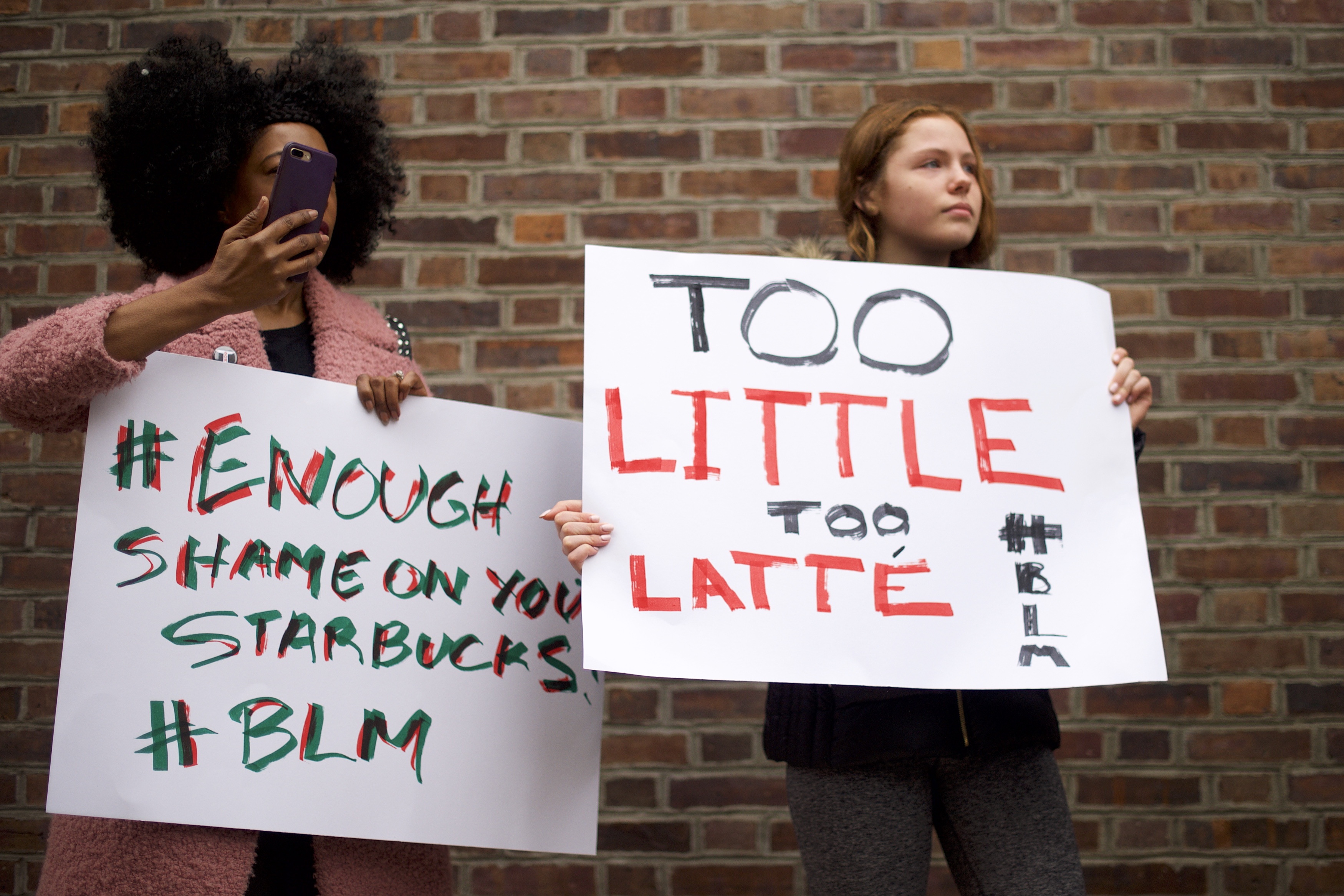 PHILADELPHIA, PA - APRIL 15: Protestors, mother and step-daughter, Donn T (L) and Soren Mcclay, 14, (R) demonstrate outside a Center City Starbucks on April 15, 2018 in Philadelphia, Pennsylvania. (Photo by Mark Makela/Getty Images)