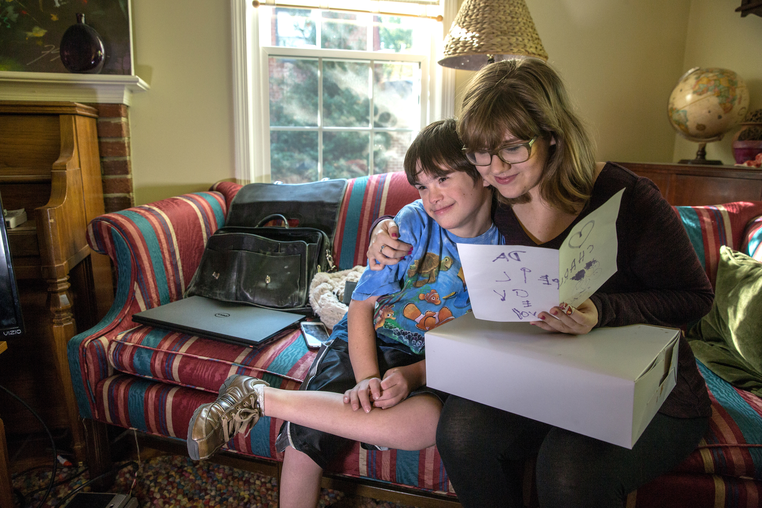 Sophia DeLoatche,17, reads the birthday card her brother Charlie made, in Falls Church, October 21, 2015. Charlie has Down syndrome and a host of other medical complications that require round-the-clock care, including a rare form of pancreatic cancer that has him on a feeding tube. Some families have been on a waiting list for years in Virginia for Medicaid vouchers that would finance various aspects of health care. (CREDIT: Evelyn Hockstein/For The Washington Post via Getty Images)