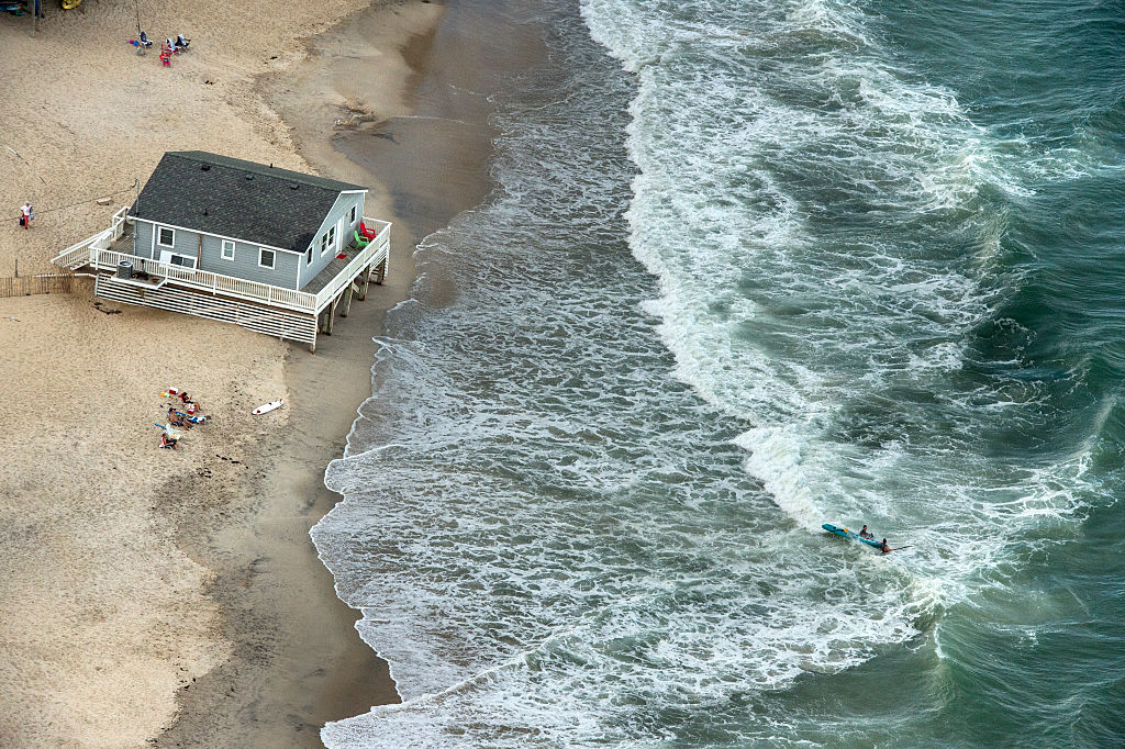 A surfer rides the waves along the coast of Outer Banks in Rodanthe, North Carolina. (Credit: Kahn/The Washington Post via Getty Images)