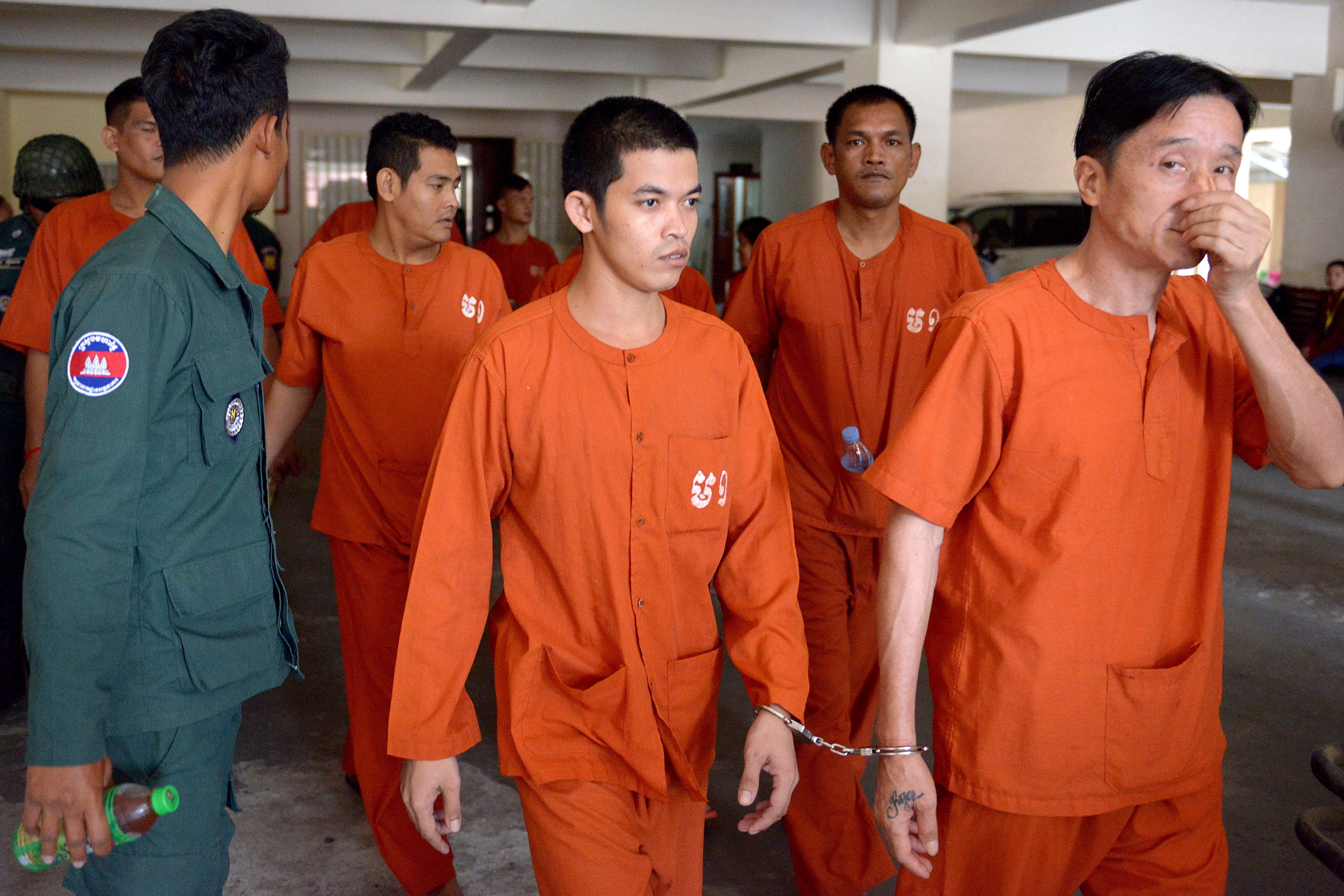 Ven Sopheap is escorted by a prison guard at the Phnom Penh municipal court on February 24, 2017. A Cambodian court sentenced the 27-year-old to two years in jail for Facebook posts that threatened Hun Sen. (Credit: TANG CHHIN SOTHY/AFP/Getty Images)