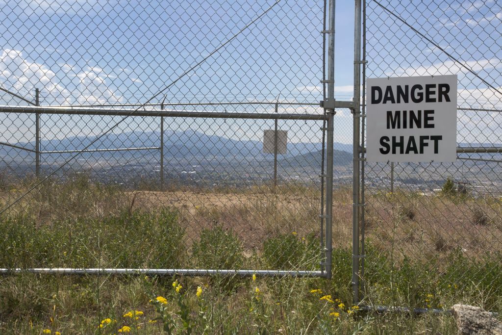 A "Danger Mine Shaft" sign is located near the Berkeley Pit on July 6, 2017 in Butte, Montana. Formerly an open pit copper mine, today the Berkeley Pit is part of the largest Superfund site in the United States. CREDIT: Janie Osborne/Getty Images