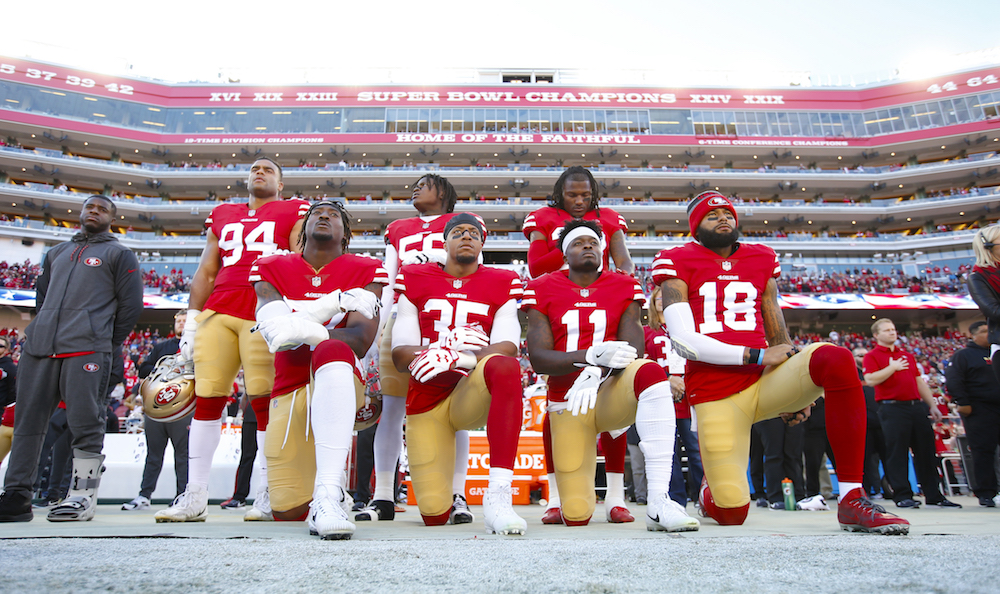SANTA CLARA, CA - DECEMBER 17: Eli Harold #57, Eric Reid #35, Marquise Goodwin #11 and Louis Murphy #18 of the San Francisco 49ers kneel on the sideline during the anthem as Solomon Thomas #94, Reuben Foster #56 and Adrian Colbert #38 stand with them in support, prior to the game against the Tennessee Titans at Levi's Stadium on December 17, 2017 in Santa Clara, California. The 49ers defeated the Titans 25-23. (Photo by Michael Zagaris/San Francisco 49ers/Getty Images)