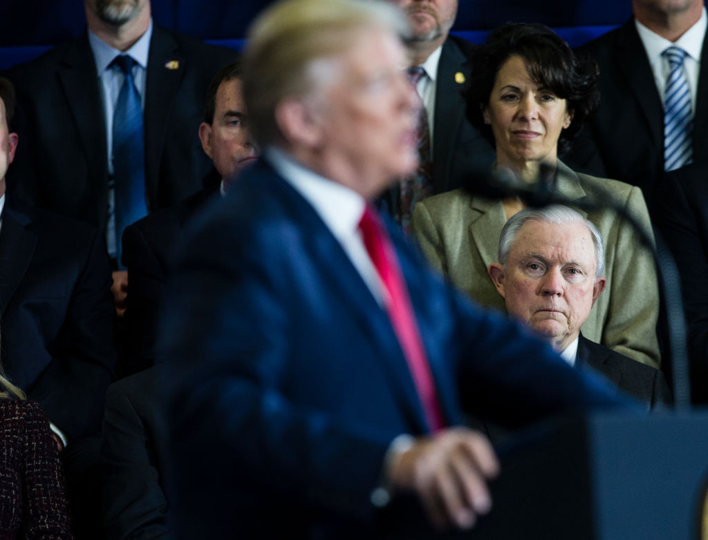 U.S. Attorney General Jeff Sessions listens as U.S. President Donald Trump delivers a speech in New Hampshire on March 19, 2018. CREDIT: Keith Bedford/The Boston Globe via Getty Images