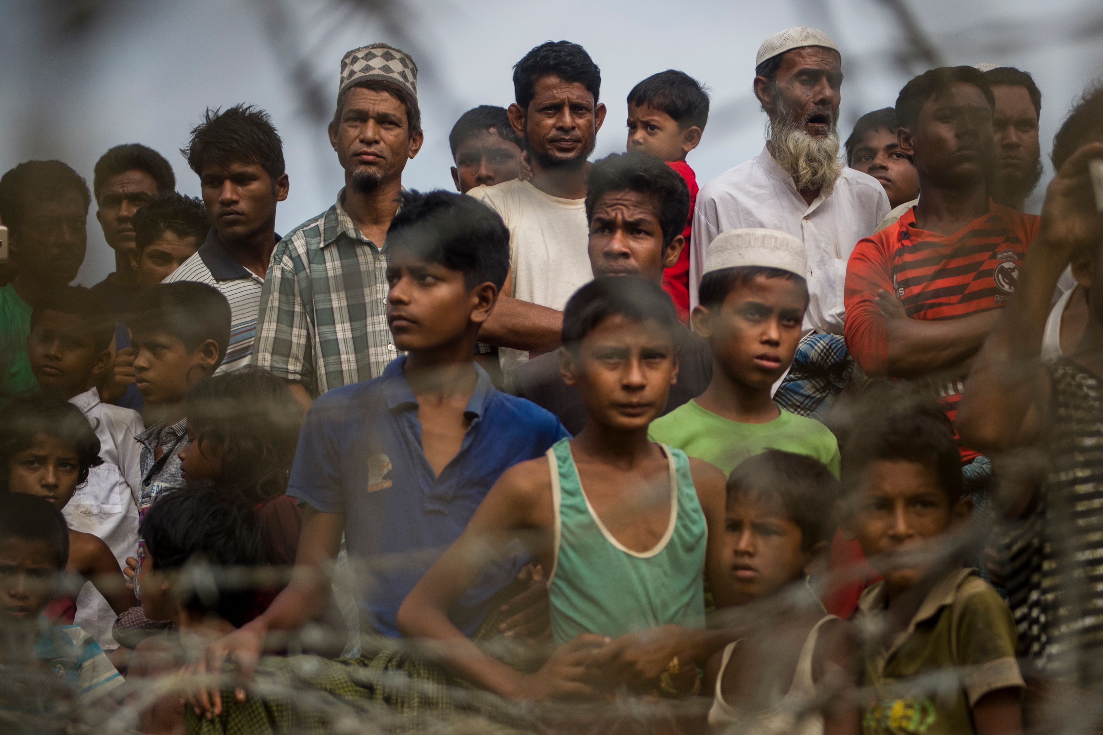 Rohingya refugees gather in the "no man's land" behind Myanmar's boder lined with barb wire fences in Maungdaw district, Rakhine state bounded by Bangladesh on April 25, 2018. CREDIT: Ye Aung Thu/AFP/Getty Images.