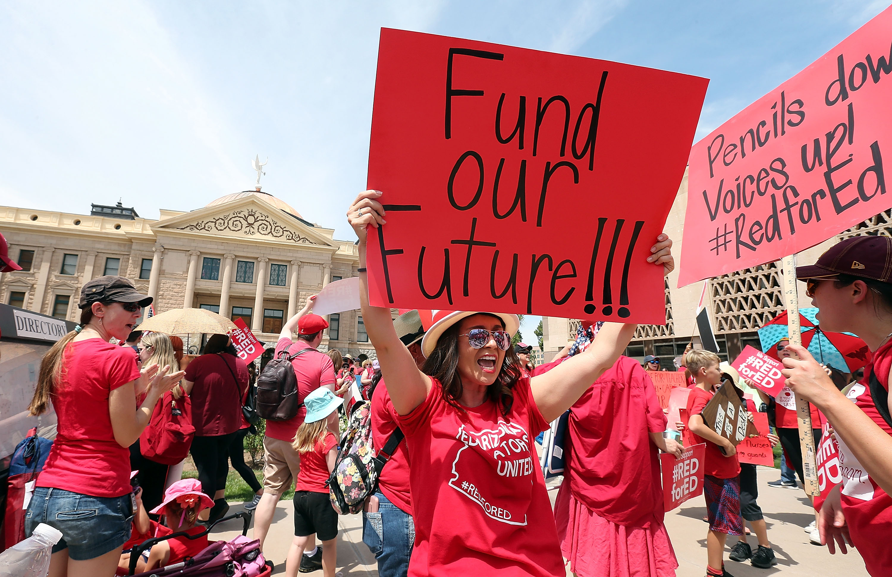 An Arizona teacher holds up a sign in front of the State Capitol during a #REDforED rally on April 26, 2018 in Phoenix, Arizona. (Credit: Ralph Freso/Getty Images)