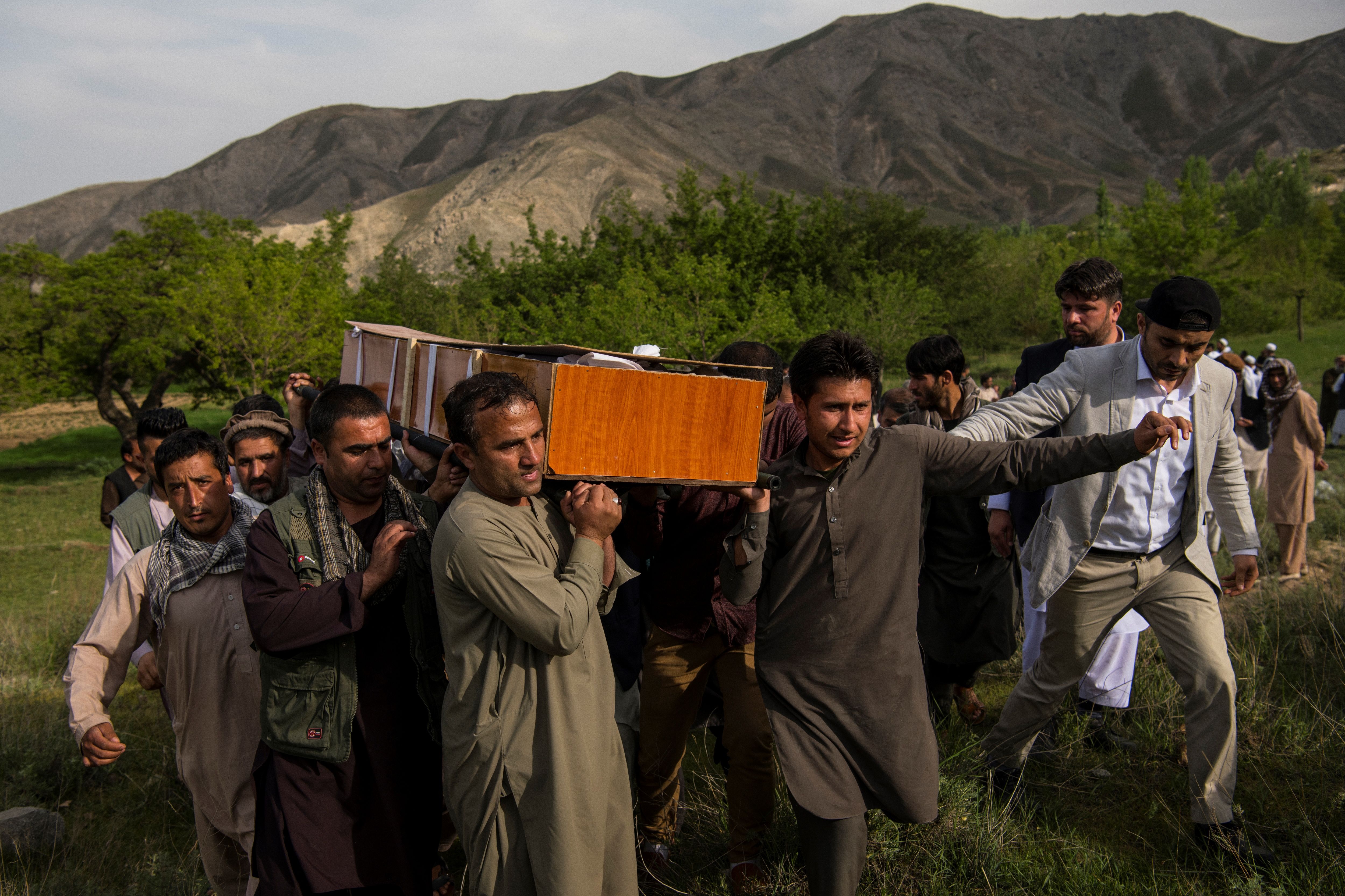 Relatives and friends of Agence France Presse Afghanistan Chief Photographer Shah Marai Faizi, including his AFP photographer colleague Wakil Kohsar (R) carry Marai's coffin before his burial in Gul Dara, Kabul on April 30, 2018, after his death in the second of two bombings that occurred in the Afghan capital. CREDIT: Andrew Quilty/AFP/Getty Images.