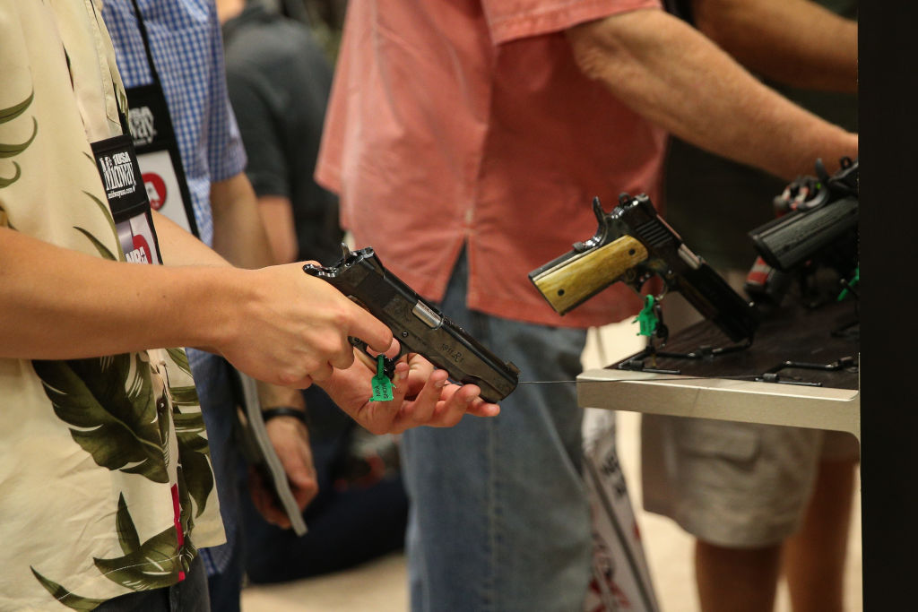 People browse firearms in an exhibit hall at the NRA's annual convention on May 4, 2018 in Dallas, Texas. CREDIT: Loren Elliott