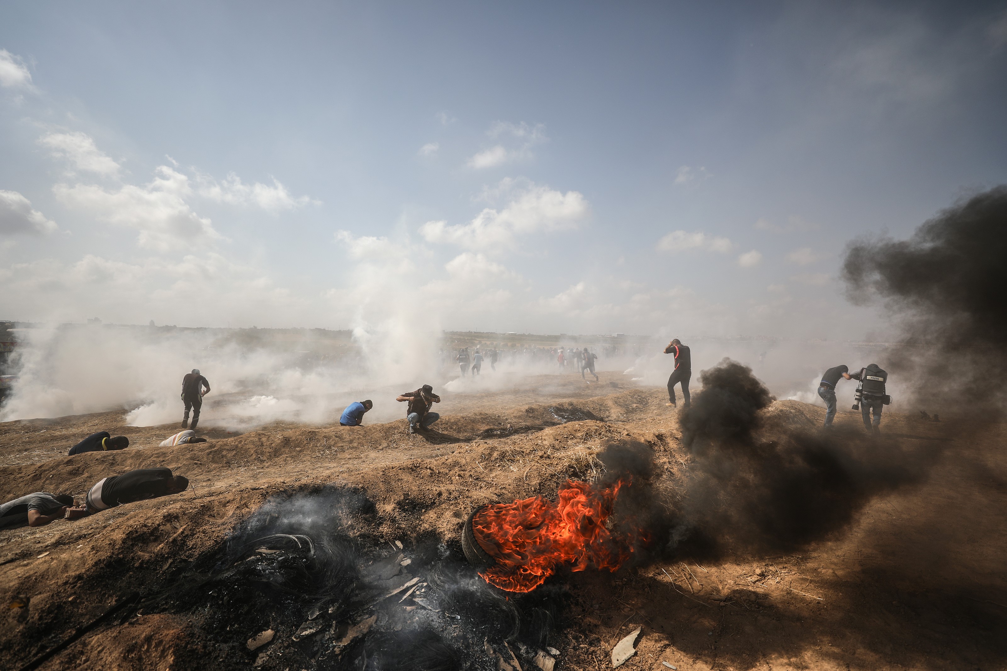 Press members and Palestinian demonstrators are affected by tear gas following Israeli forces' intervention during a protest within the "Great March of Return" near Israeli border in eastern part of Shuja'iyya neighborhood of Gaza City, Gaza on May 11, 2018.
(CREDIT: Ali Jadallah/Anadolu Agency/Getty Images)
