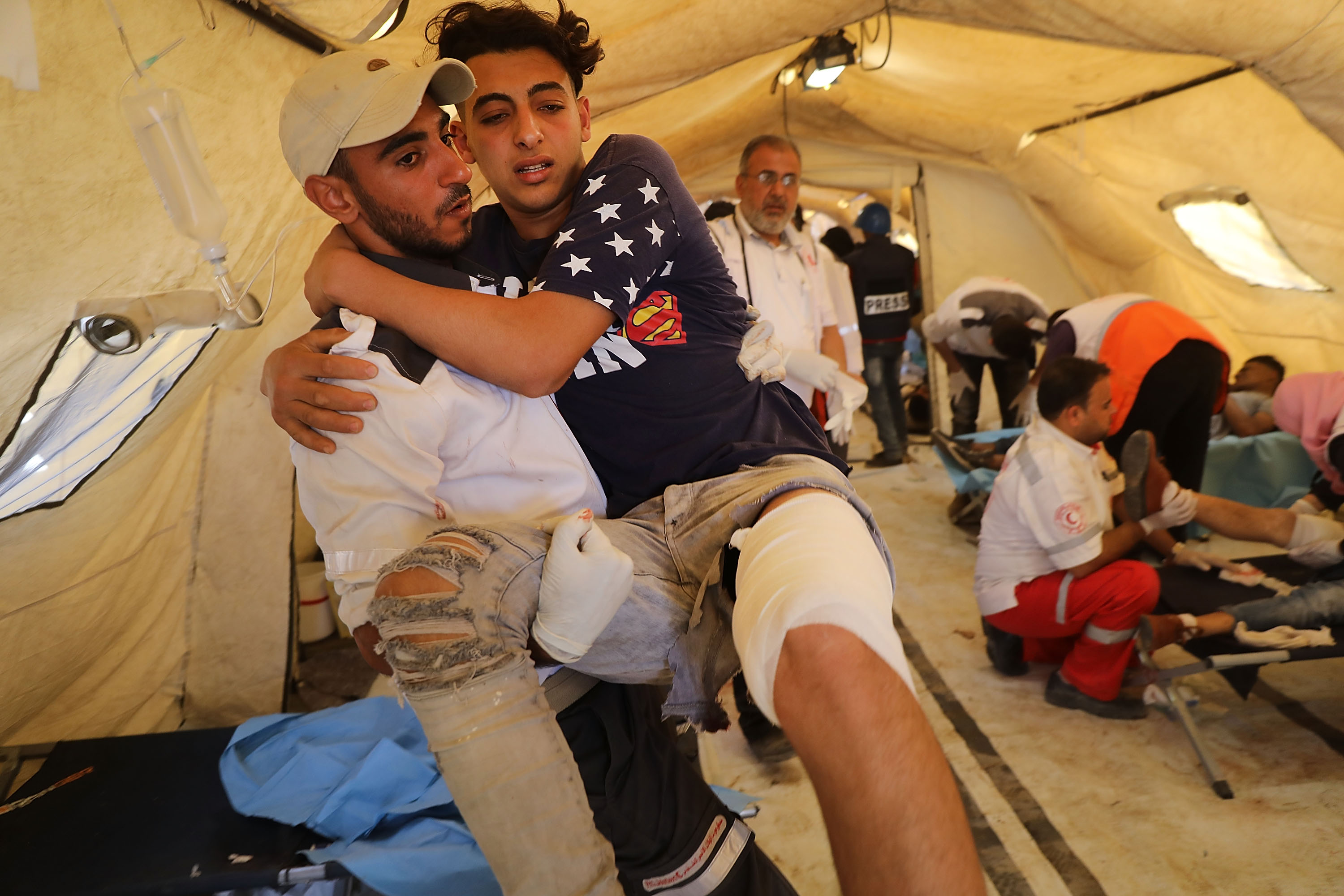 A wounded Palestinian protester arrives at a field hospital near the border fence with Israel as mass demonstrations continue on May 14, 2018 in Gaza City, Gaza. CREDIT: Spencer Platt/Getty Images.