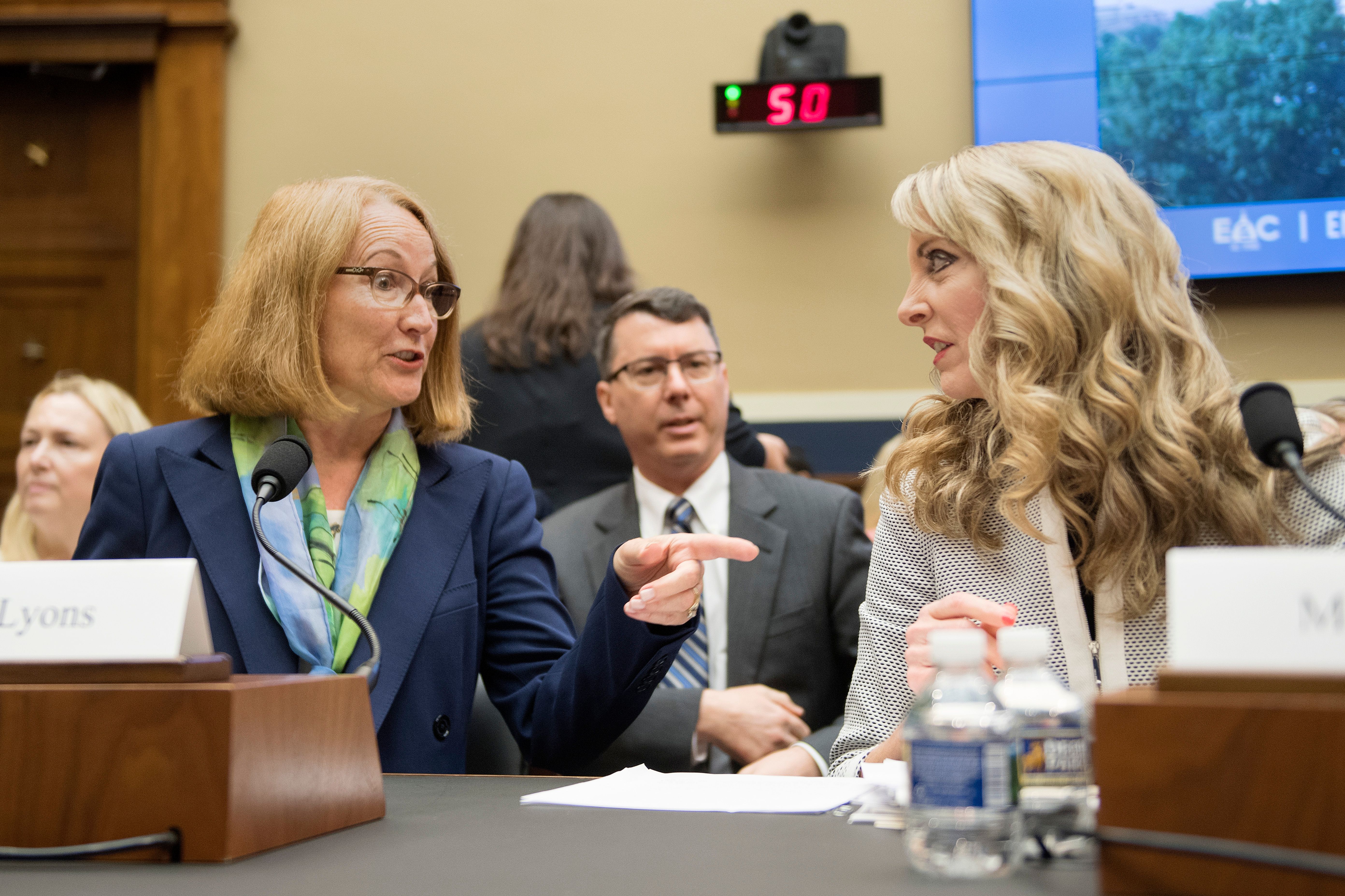 Acting CEO of the United States Olympic Committee Susanne Lyons (L) talks with President and CEO of USA Gymnastics Kerry Perry (R) prior to testifying before the House Energy and Commerce Oversight and Investigations Subcommittee hearing on "Examining the Olympic Community's Ability to Protect Athletes from Sexual Abuse" in Washington, DC, on May 23, 2018. (Photo by JIM WATSON / AFP) (Photo credit should read JIM WATSON/AFP/Getty Images)