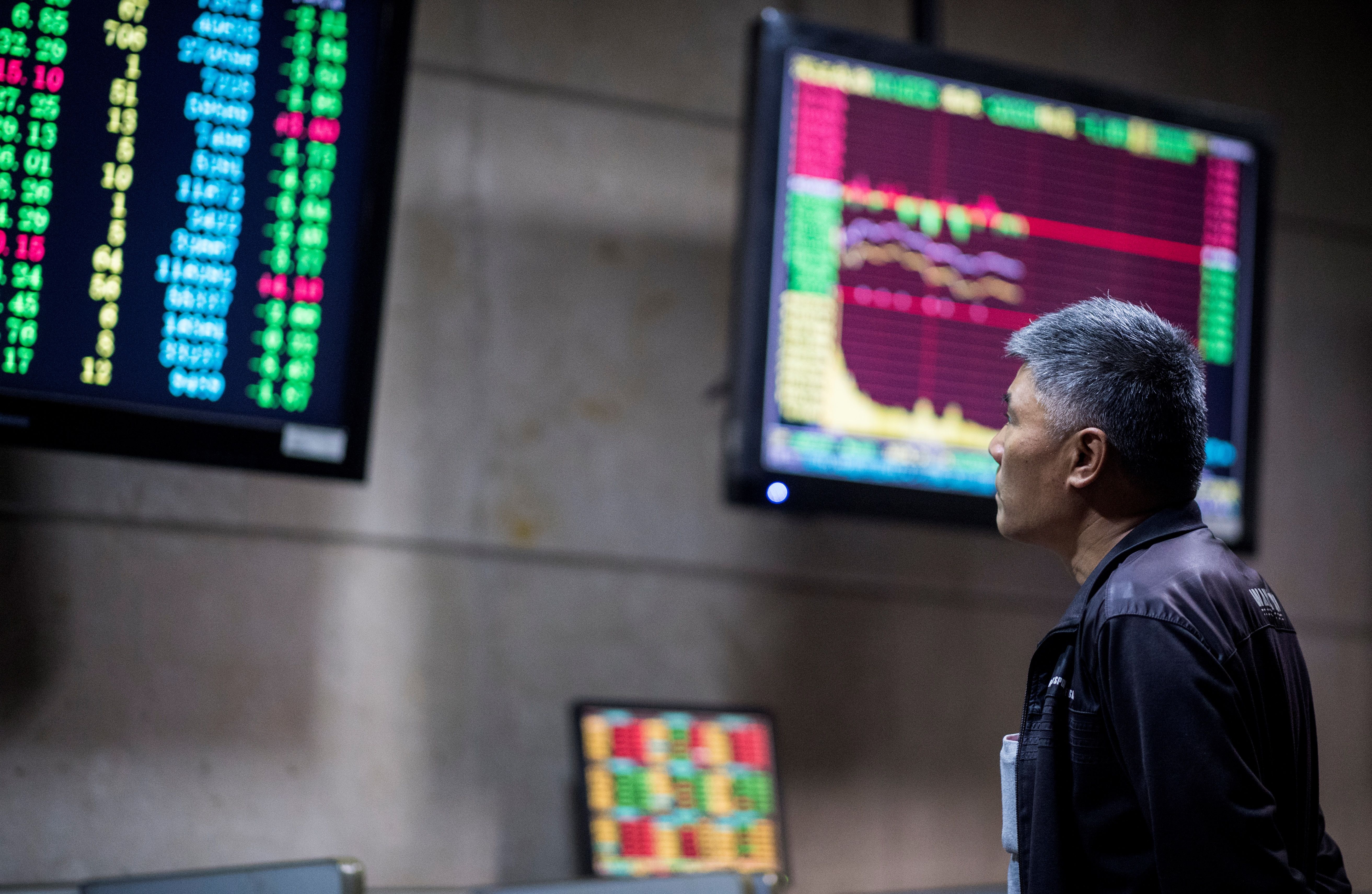 An investor monitors stock prices at a securities company in Shanghai on May 30, 2018. Asian equities sank as turmoil in Italy sparked as investors have also been spooked by fresh worries about the China-US trade row. (CREDIT: Johannes Eisele/Getty Images)