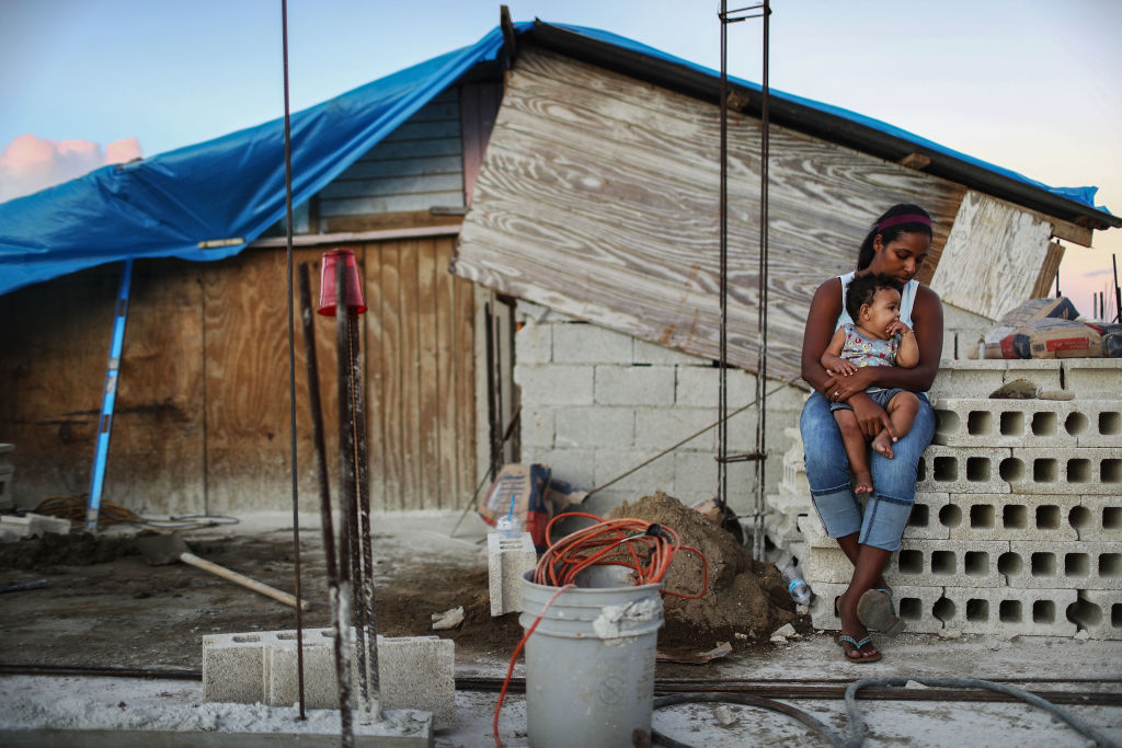 On December 23, 2017, a mother holds her nine-month-old baby, at their makeshift home, under reconstruction, after being mostly destroyed by Hurricane Maria, in San Isidro, Puerto Rico. CREDIT: Mario Tama/Getty Images