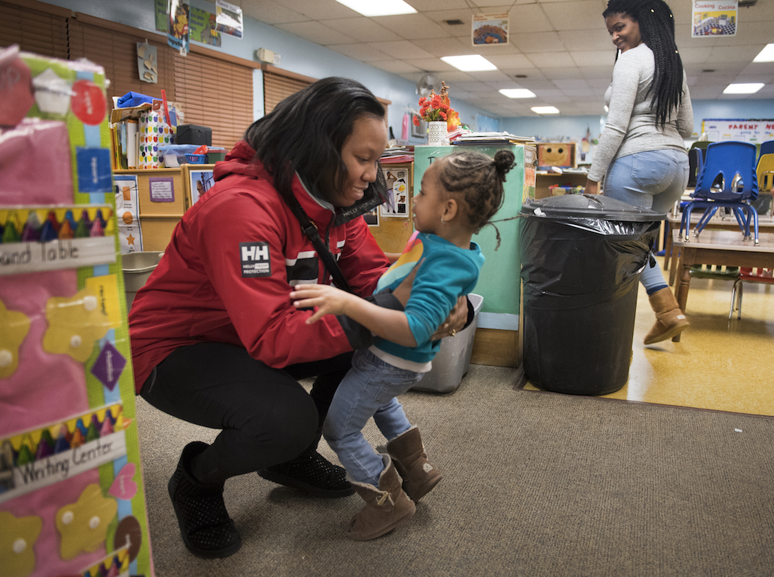 Single mother Monique Burton picks up her daughter Jalayna Elam, age 2 and six year old son (not pictured) from the Greenbelt Children's Center daycare in Greenbelt, MD on December 20, 2016. (CREDIT: Photo by Linda Davidson/The Washington Post via Getty Images)