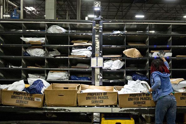 An employee sorts packages inside the United Parcel Service Inc. (UPS) Chicago Area Consolidation Hub. (Credit: Daniel Acker/Bloomberg via Getty Images)
