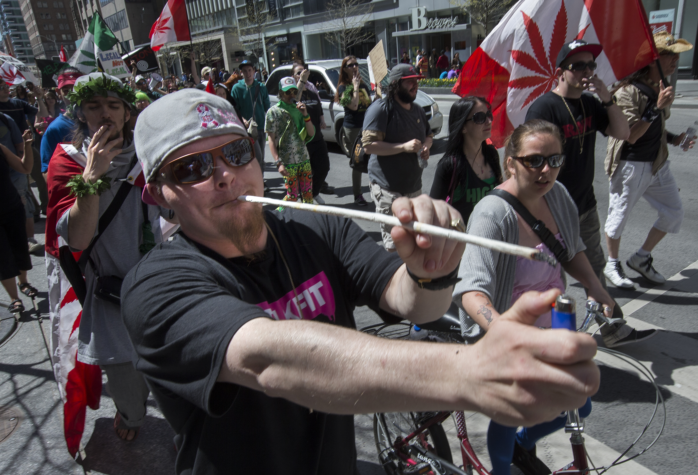 Alan Edwards, of Toronto, can barely reach to light the end of a joint he rolled while marching with other protesters along Bloor Street, demanding the legalization of marijuana, that the province release the findings of its 1972 study into the effects of marijuana use, and that vapor lounges be allowed to remain open. May 4, 2013. (CREDIT: Bernard Weil/Toronto Star via Getty Images)