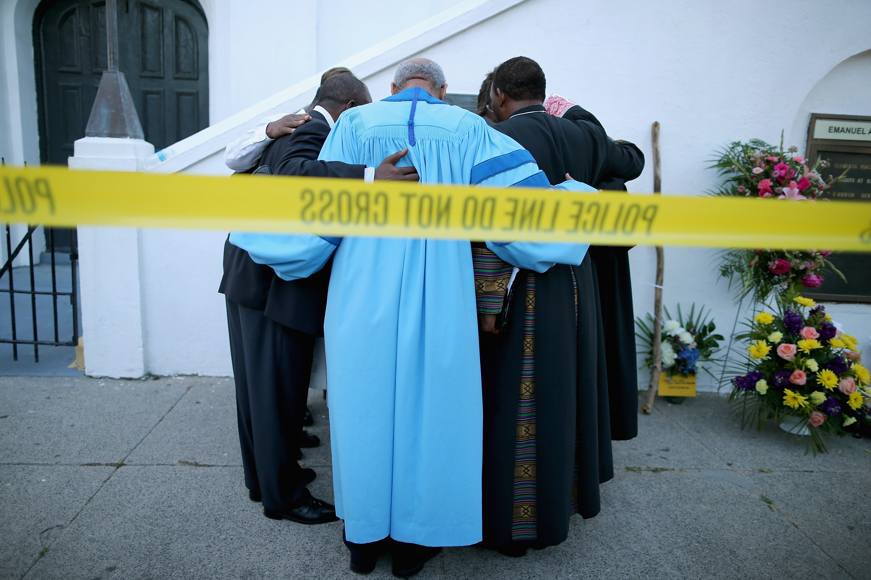 Rev. Sidney Davis and other area pastors pray outside Emanuel AME Church in Charleston after Dylann Roof opened fire, killing 9. CREDIT: Chip Somodevilla/Getty Images