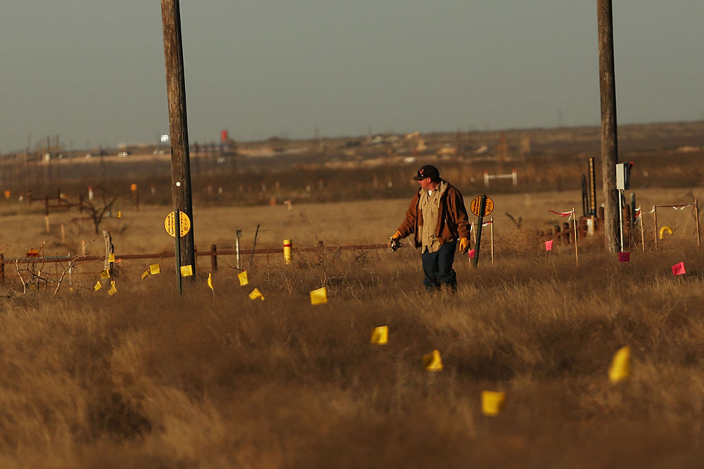 A worker in the oil industry walks through an area where a new pipeline is being laid in the Permian Basin oil field on January 21, 2016 in the oil town of Midland, Texas. CREDIT: Spencer Platt/Getty Images