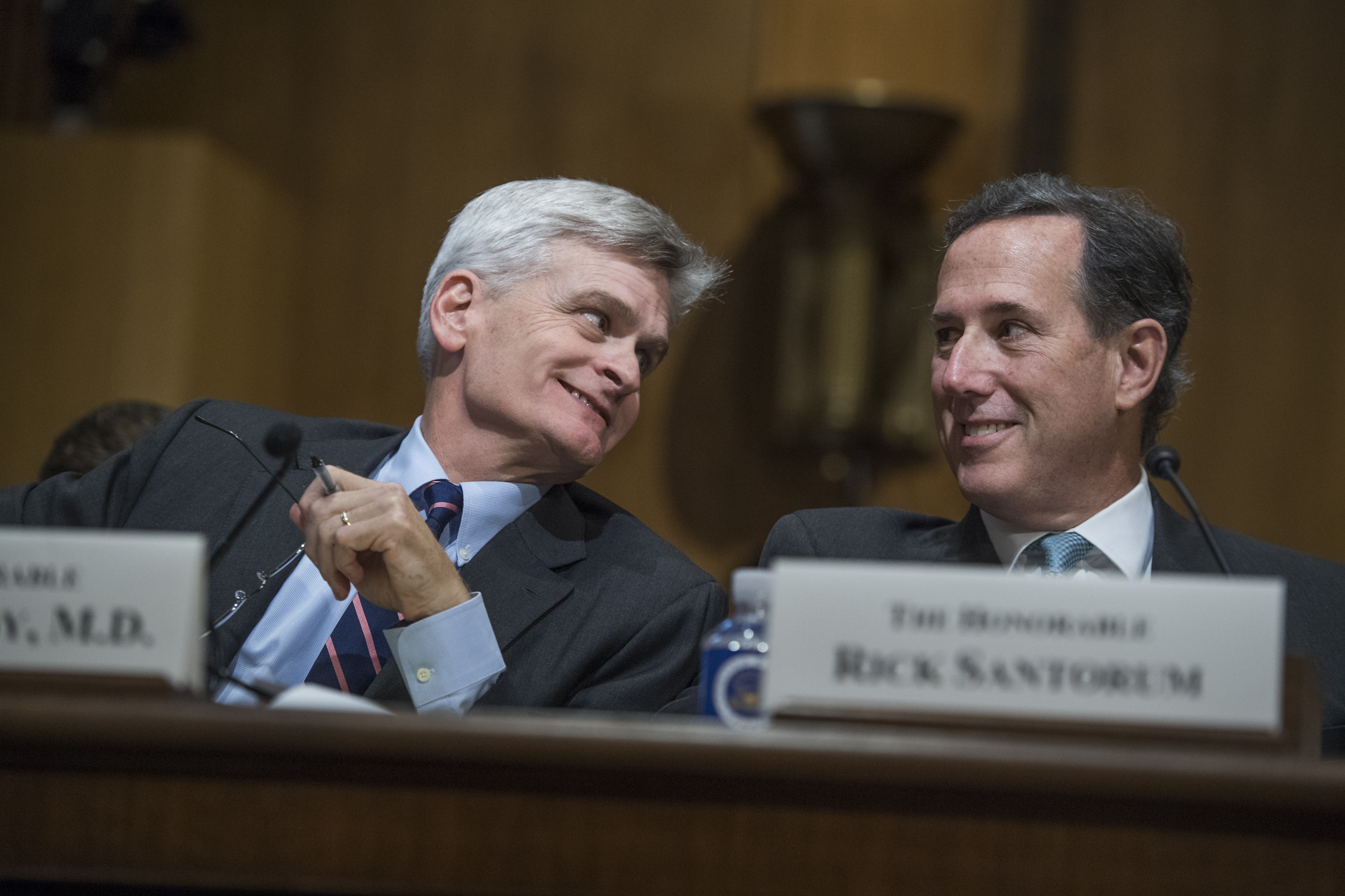 UNITED STATES - SEPTEMBER 25: Sen. Bill Cassidy, R-La., and former Sen. Rick Santorum, R-Pa., confer during a Senate Finance Committee hearing on the proposal by Cassidy and Sen. Lindsey Graham, R-S.C., to repeal and replace the Affordable Care Act on September 25, 2017. (Photo By Tom Williams/CQ Roll Call)