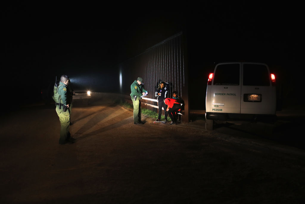 A Honduran family stands next to the U.S.-Mexico border fence after they turned themselves in to Border Patrol agents on February 22, 2018 near Penitas, Texas. CREDIT: Photo by John Moore/Getty Images