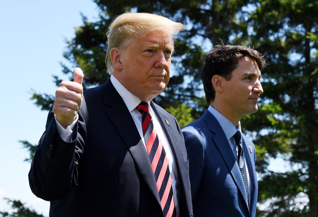 U.S. President Donald Trump (L) gives a thumbs up to the media as he is greeted by Prime Minister of Canada Justin Trudeau during the G7 official welcome at Le Manoir Richelieu. CREDIT: Leon Neal/Getty Images