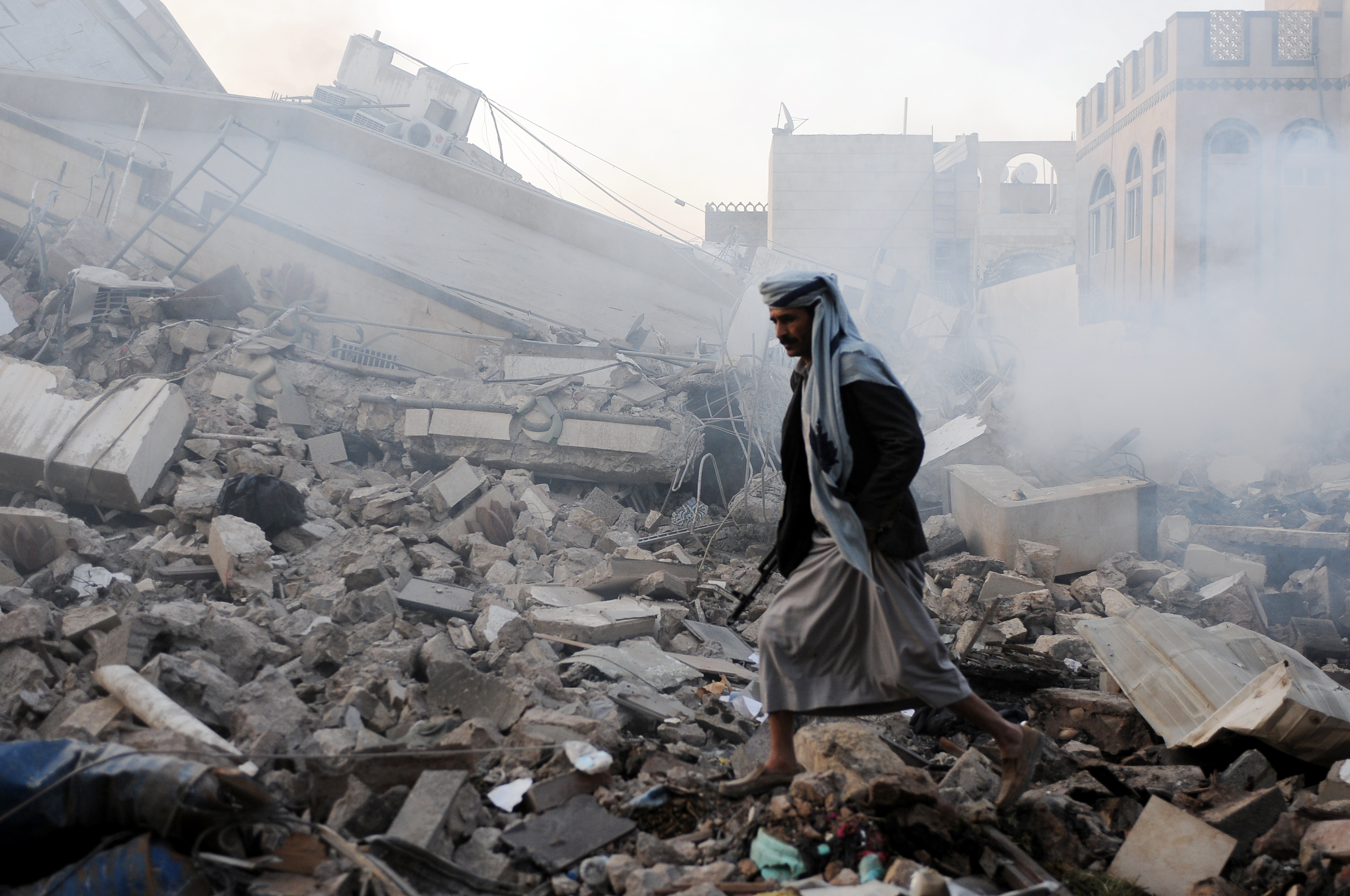 A man walks on rubble of a building destroyed in airstrikes carried out by warplanes of the Saudi-led coalition hours after the UN Special Envoy to Yemen Martin Griffiths departed the city on June 6, 2018. (CREDIT: Mohammed Hamoud/Getty Images)