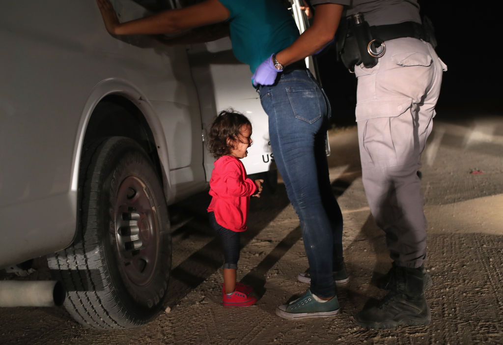 A two-year-old Honduran asylum seeker cries as her mother is searched and detained near the U.S.-Mexico border on June 12, 2018 in McAllen, Texas. CREDIT: John Moore/Getty Images